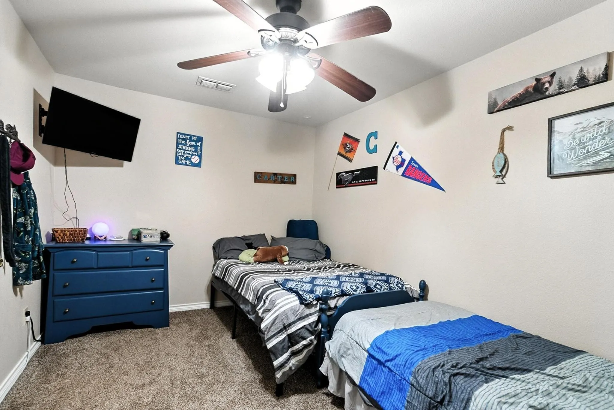 Carpeted bedroom with a ceiling fan and baseboards