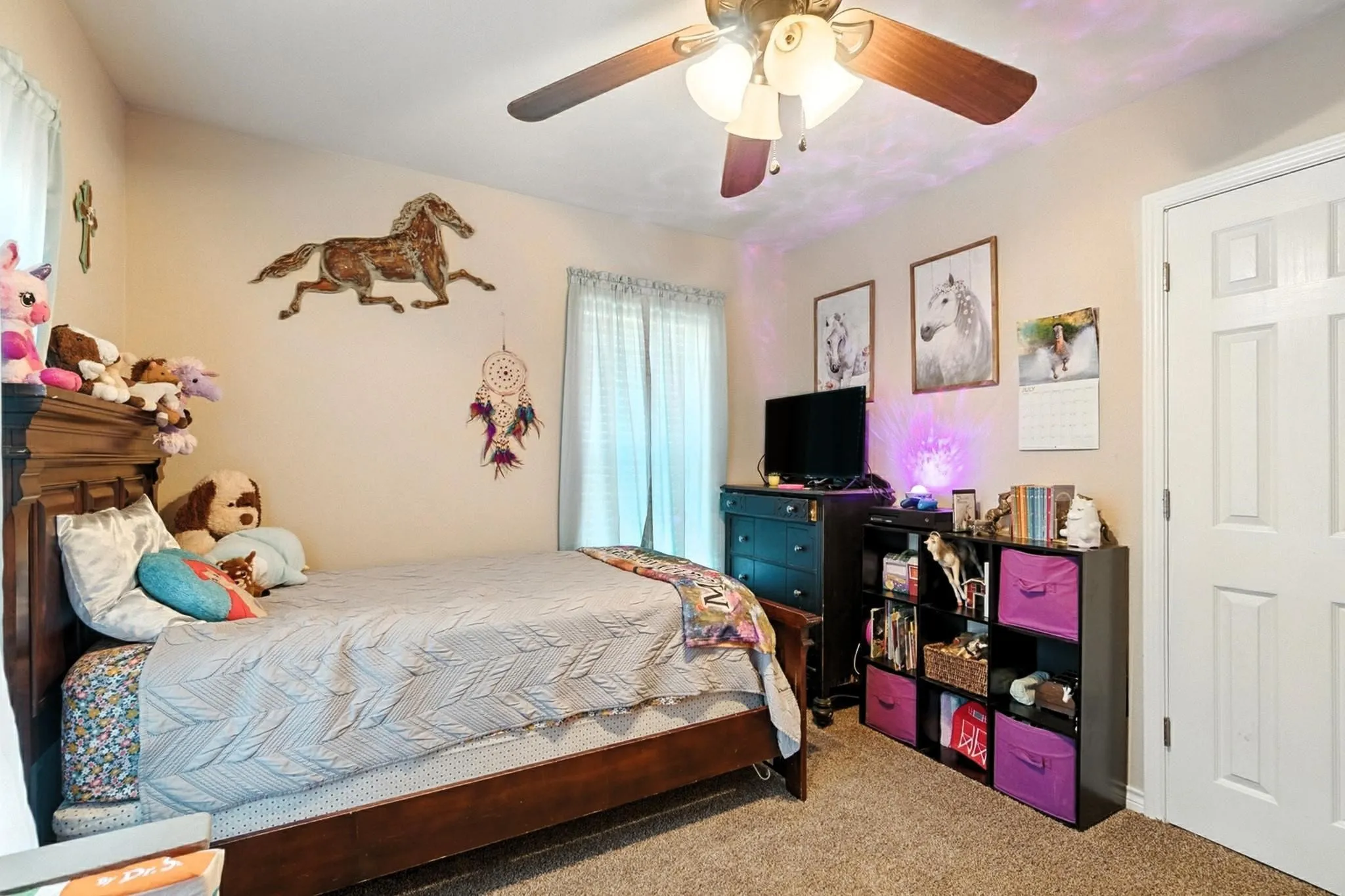 Carpeted bedroom featuring ceiling fan
