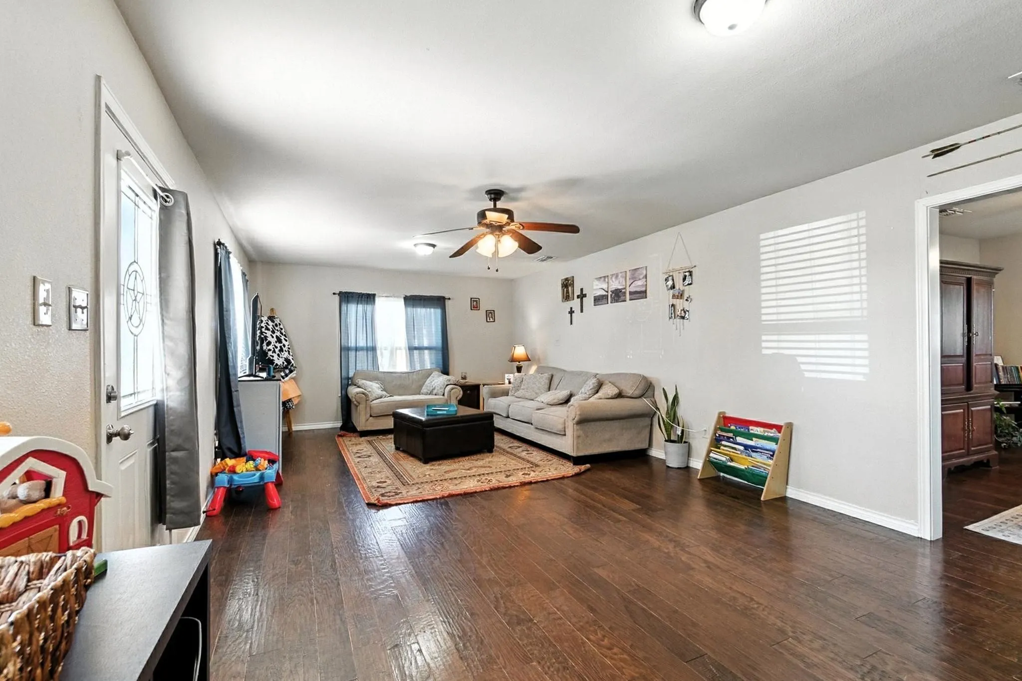 Living area with ceiling fan and wood-type flooring