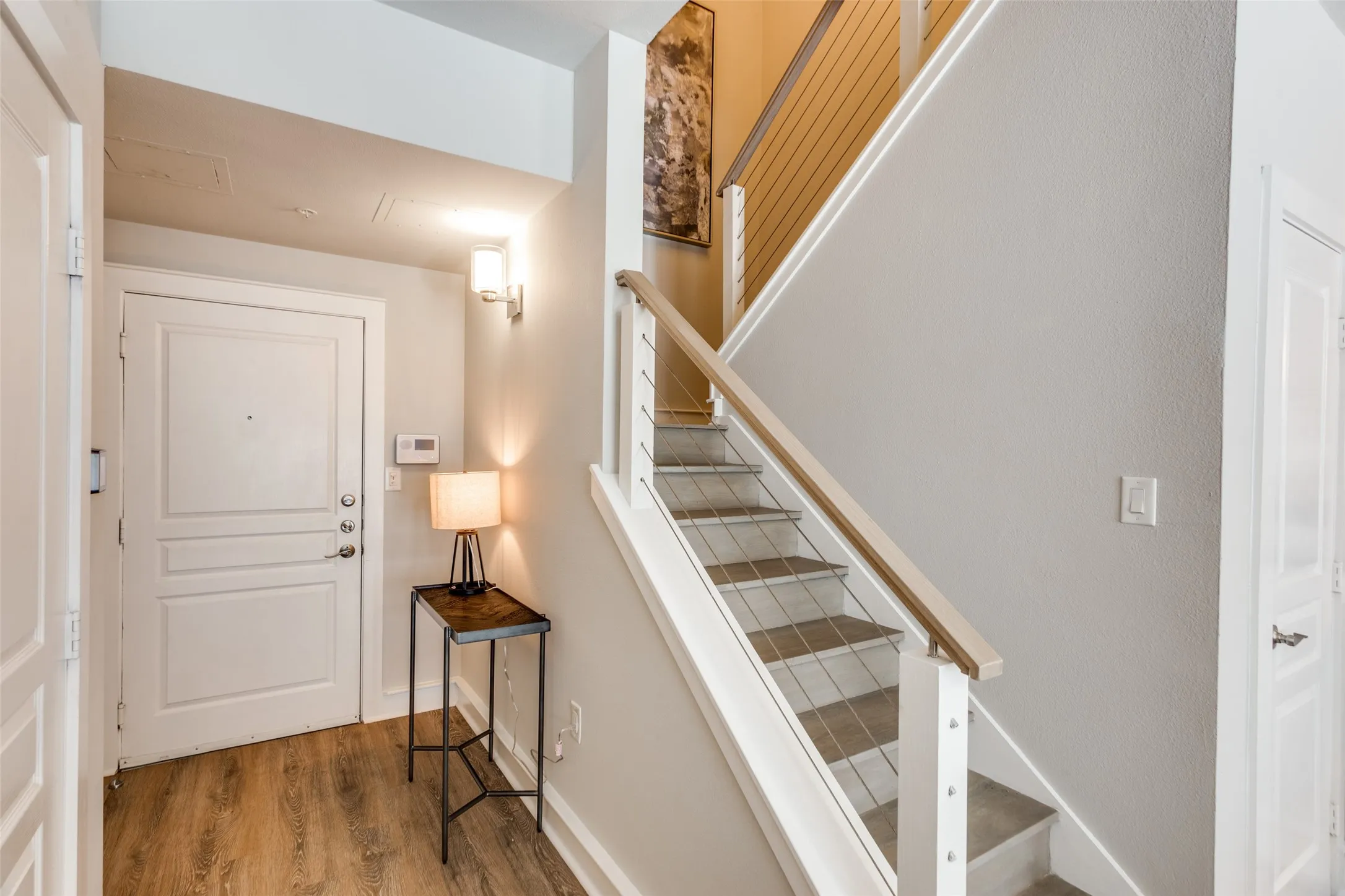 This is a view of the updated staircase that leads to the second level. The door to the half bath is on the left and the door to the right is for an under the staircase closet.
