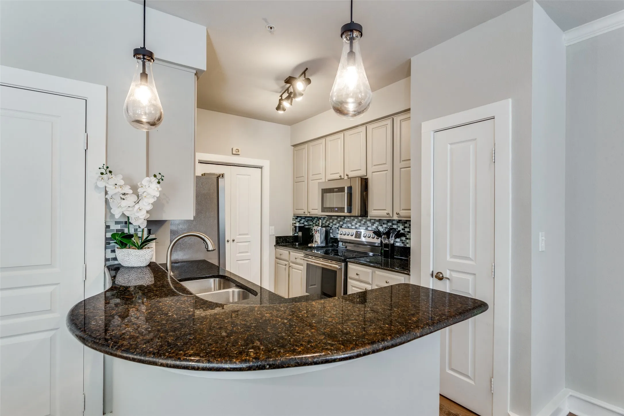 The breakfast bar allows guests to visit while you're preparing meals. The pantry is behind the door on the right.