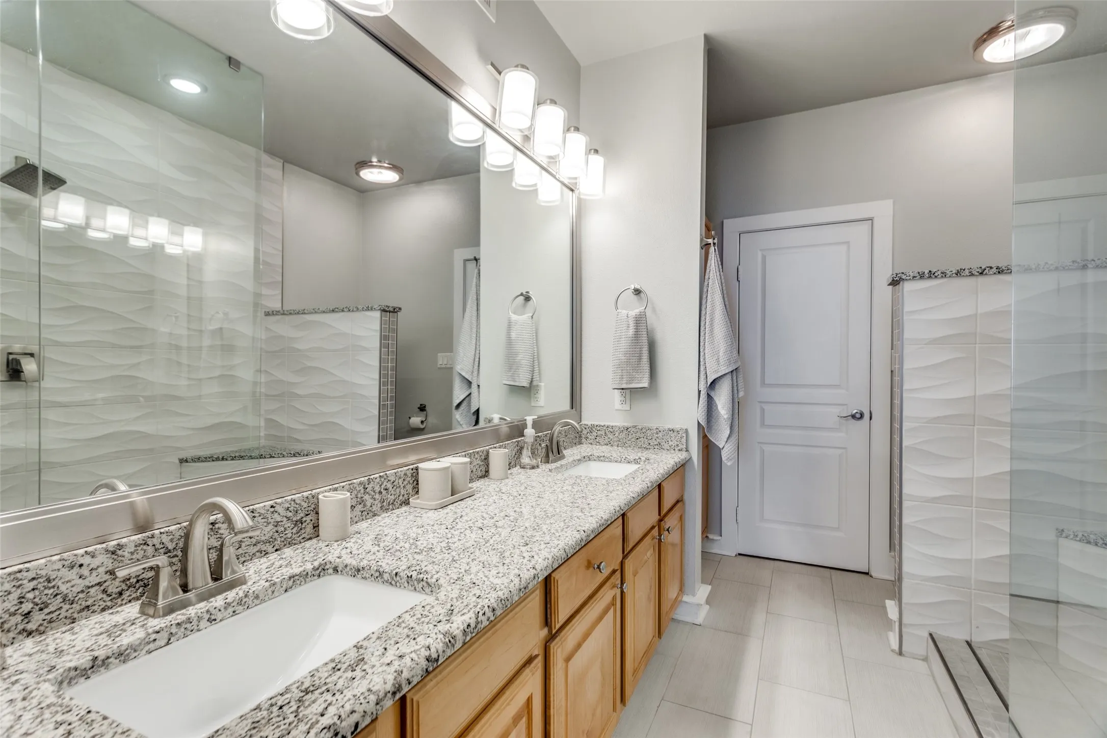 The ensuite bathroom has dual sinks, a walk-in shower, lots of cabinets and a walk-in closet.