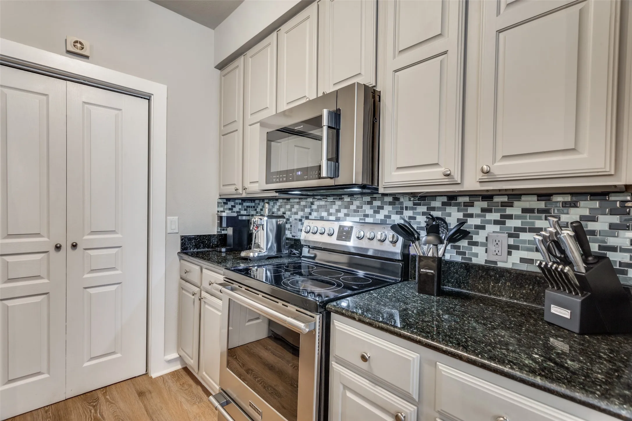 A closer view of the counter space and tile backsplash.