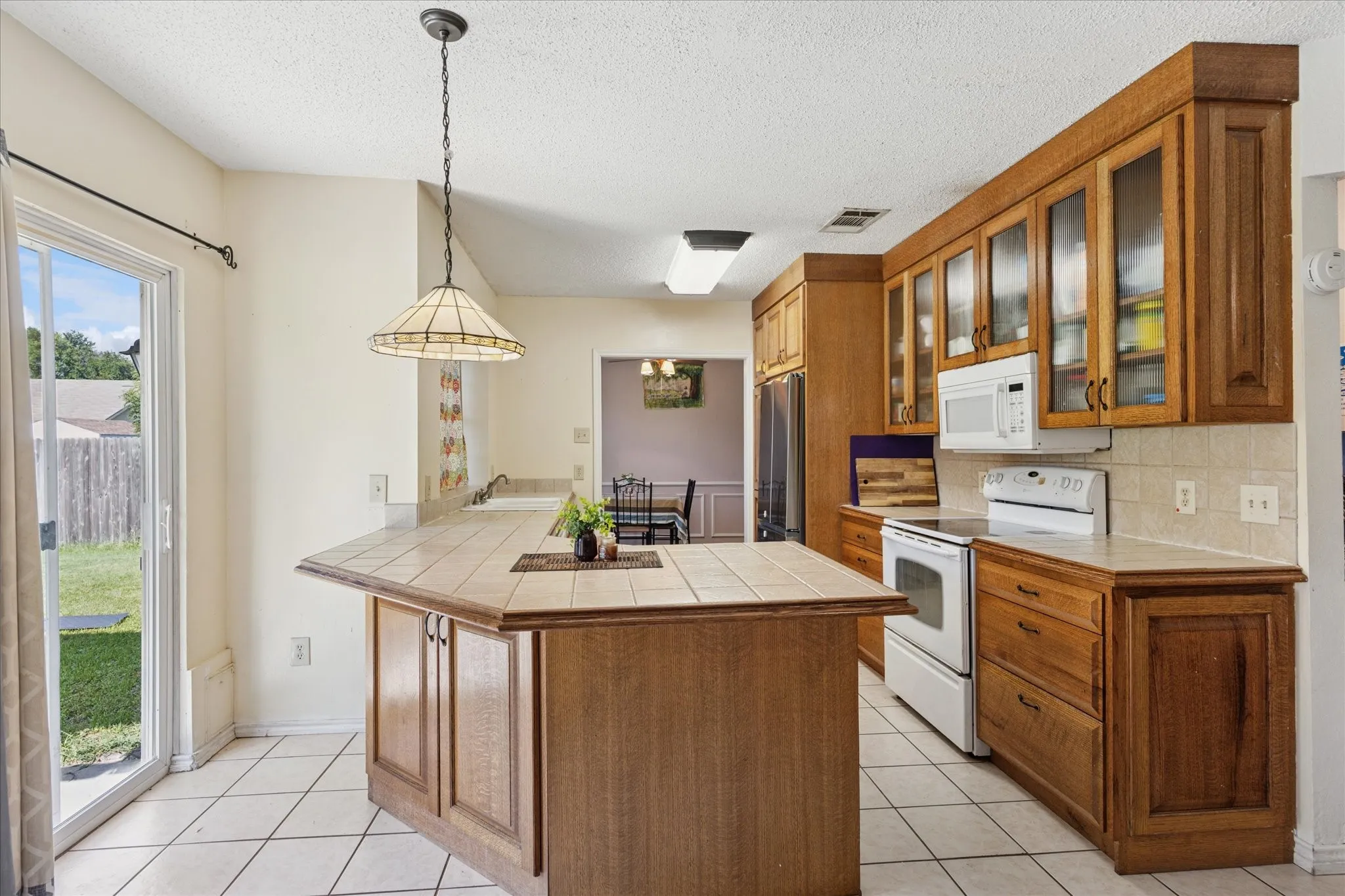 Glass cabinets doors and lots of prep space. Room for bar stools. Sliding roors to the backyard