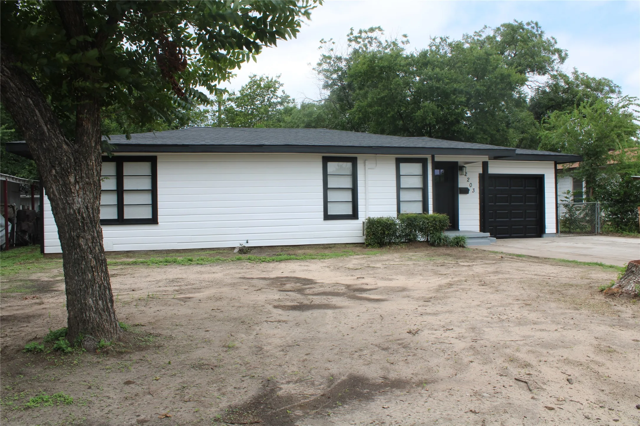 View of front facade featuring concrete driveway and an attached garage