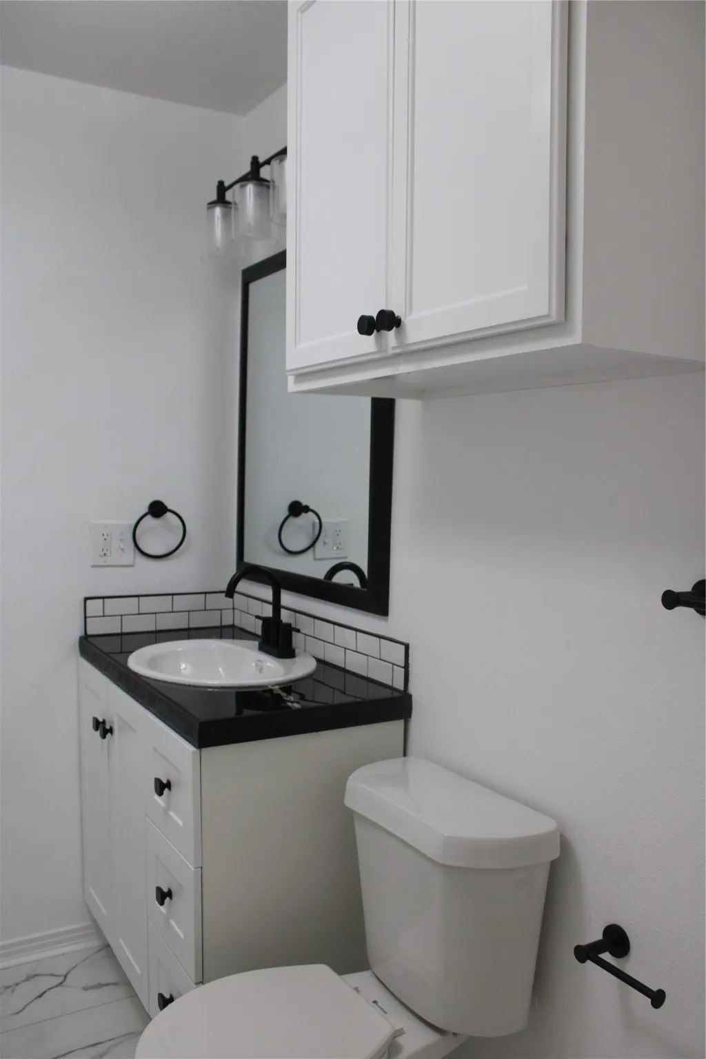 Half bath featuring vanity and marble finish floors