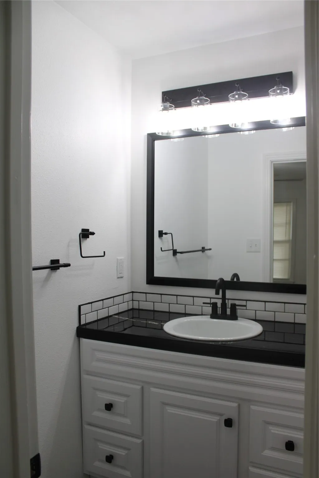 Bathroom featuring vanity and decorative backsplash