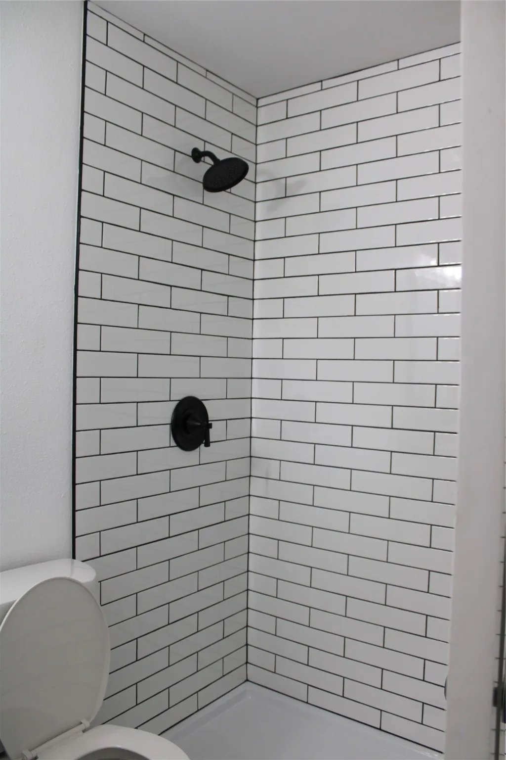 Bathroom with a shower stall and toilet