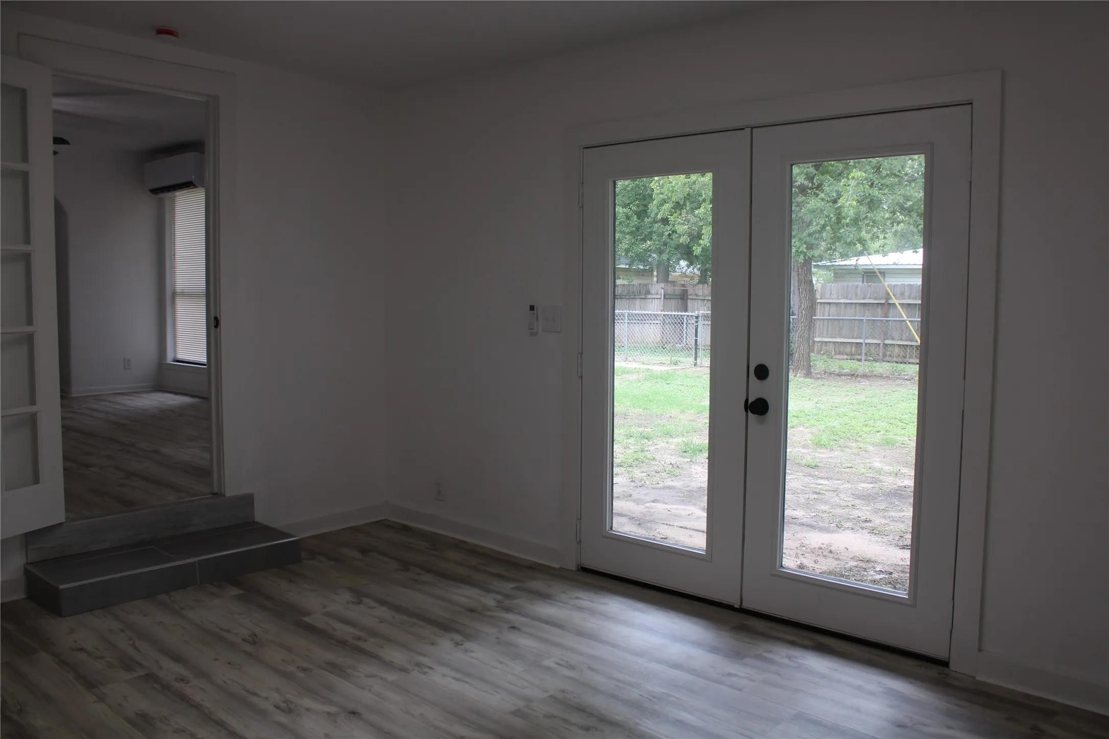 Doorway to outside with french doors, a wall mounted air conditioner, and wood finished floors