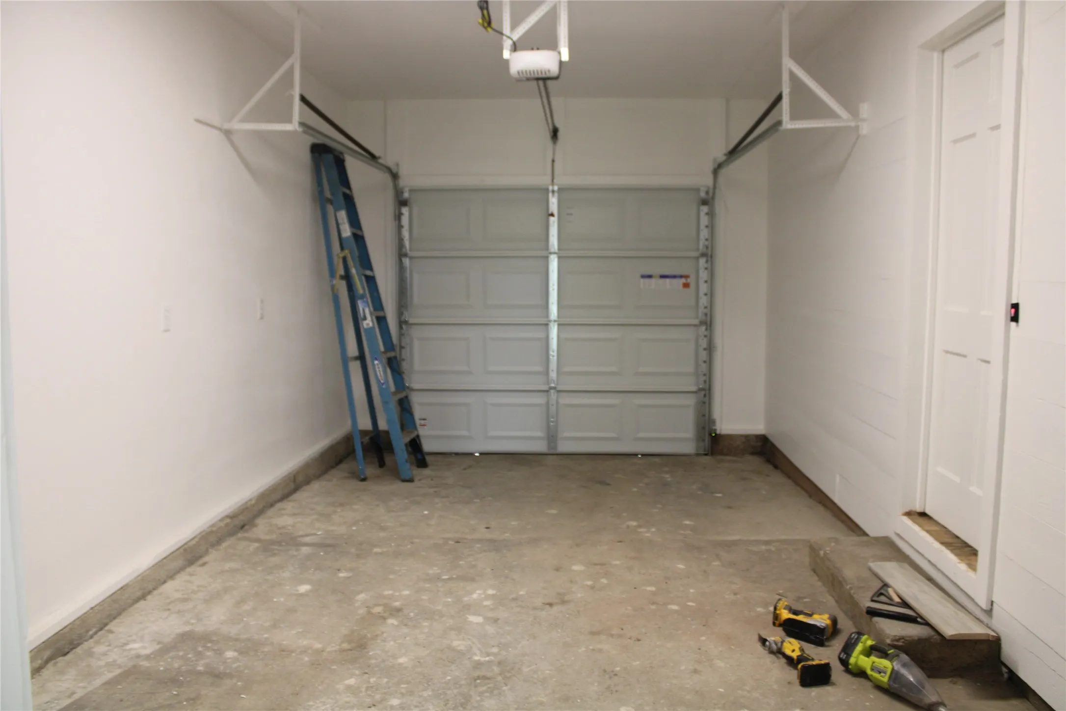 Garage with a garage door opener and baseboards
