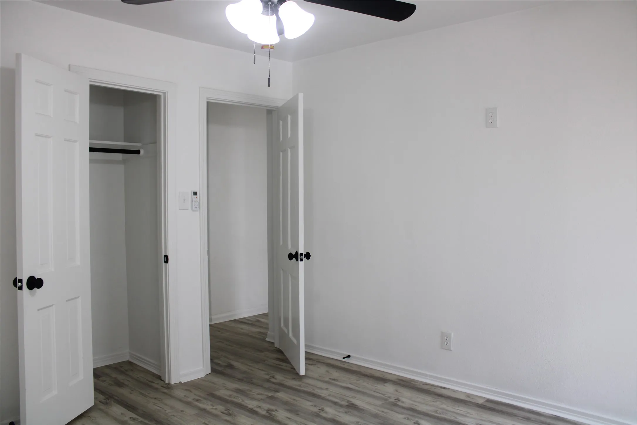 Unfurnished bedroom with wood finished floors, a closet, and a ceiling fan