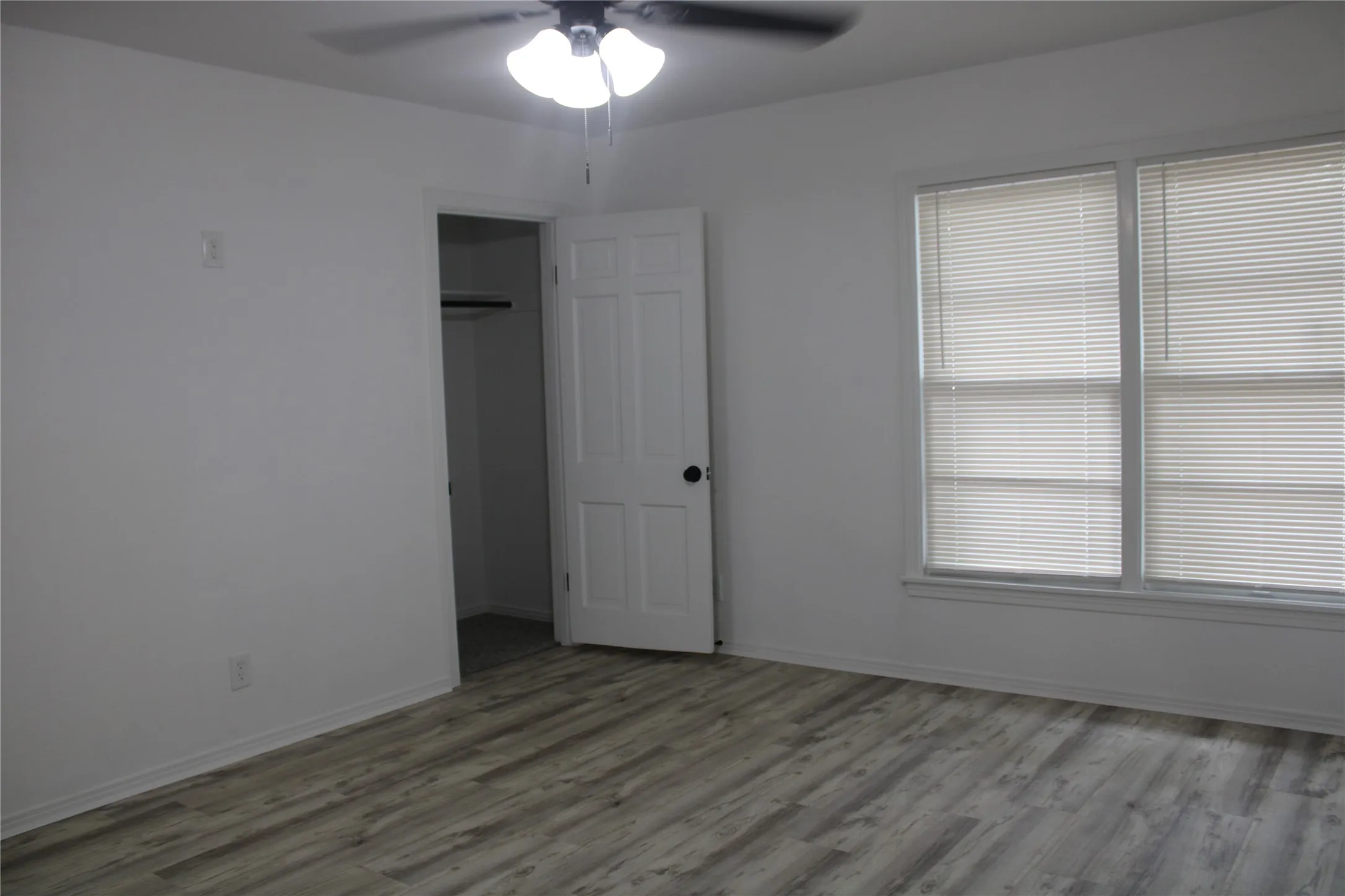 Unfurnished bedroom featuring wood finished floors, a ceiling fan, and a closet