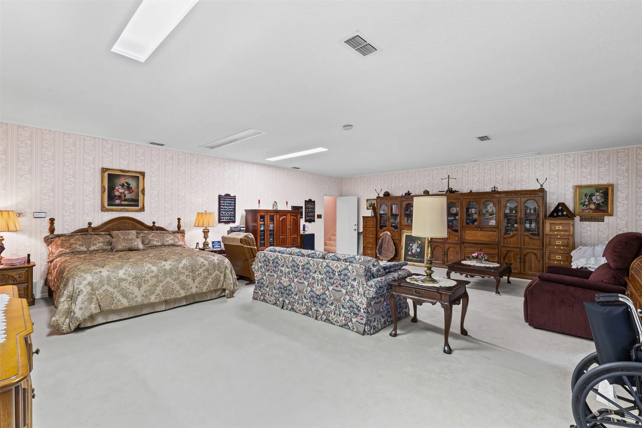 Bedroom with wallpapered walls and carpet