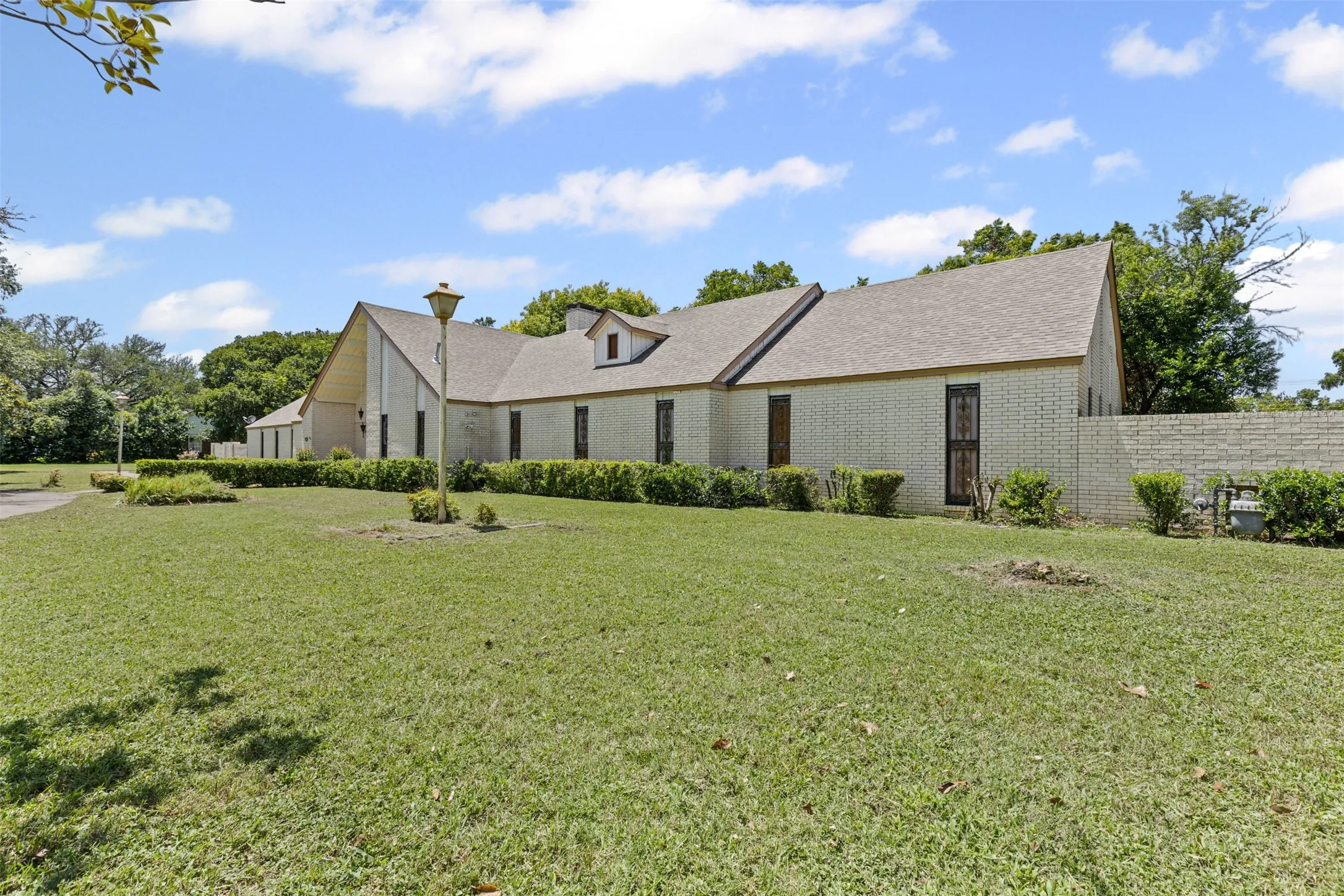 View of front of property with brick siding and roof with shingles