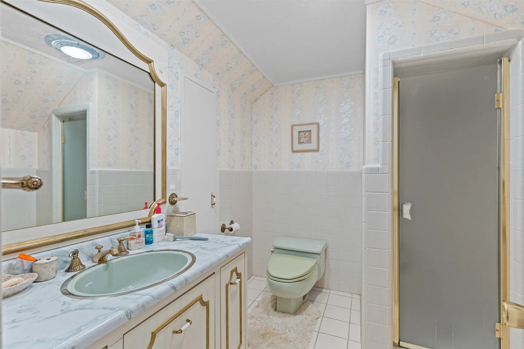 Full bath with wallpapered walls, vanity, a wainscoted wall, a shower stall, and tile patterned floors