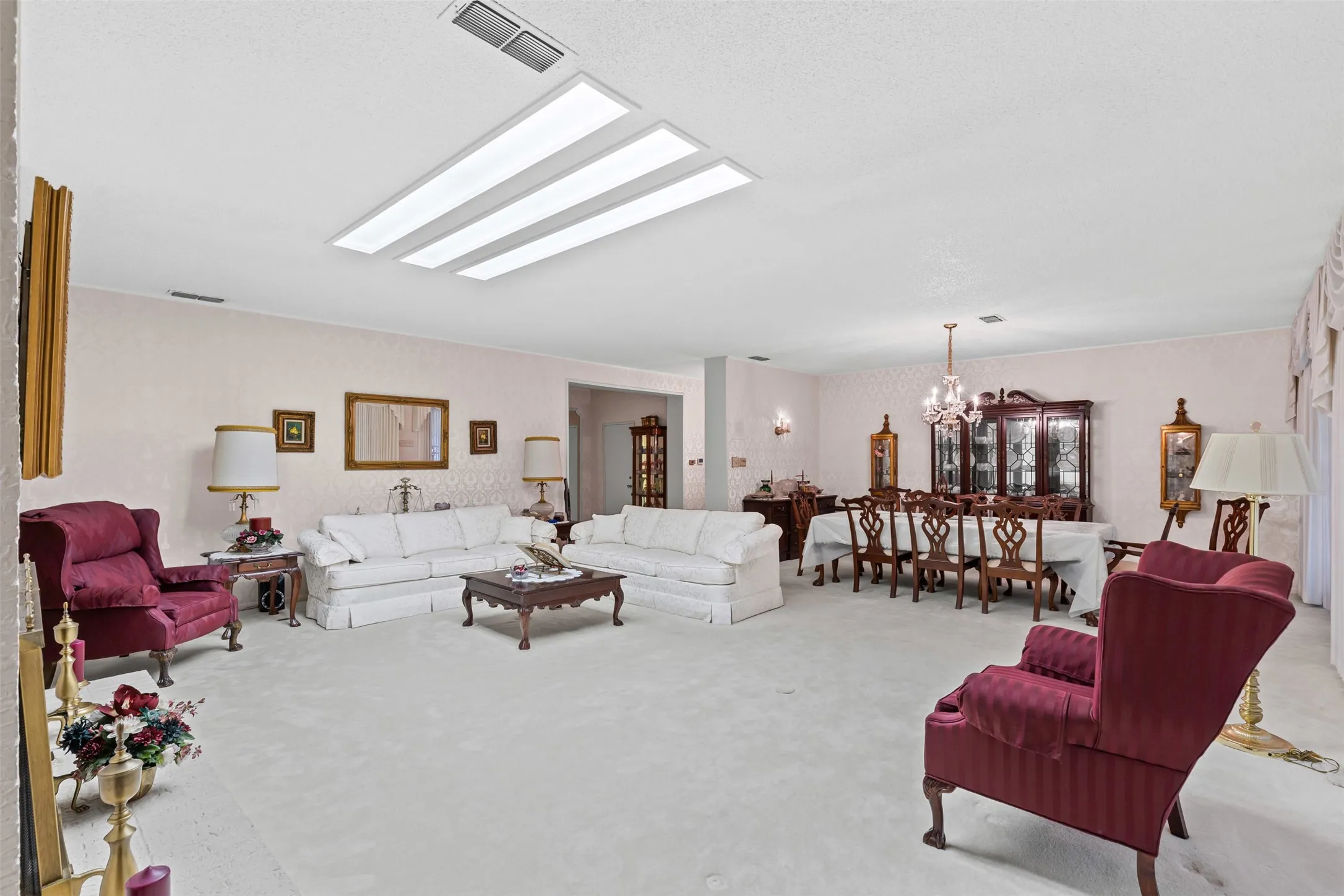 Carpeted living room with a chandelier