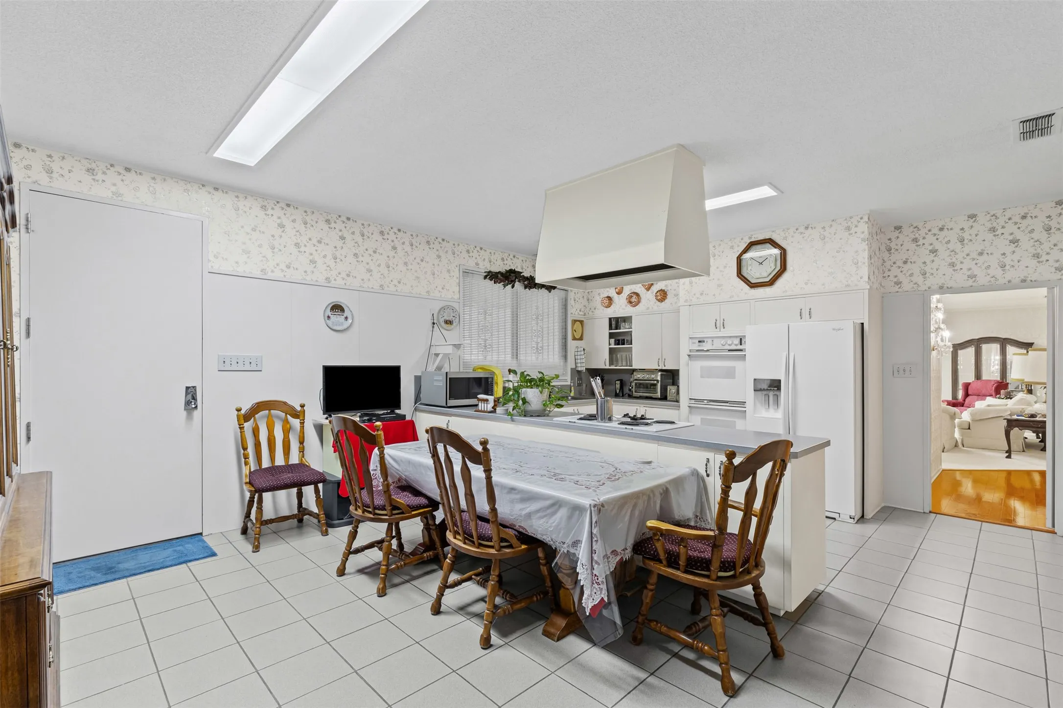 Dining space with wallpapered walls and light tile patterned floors