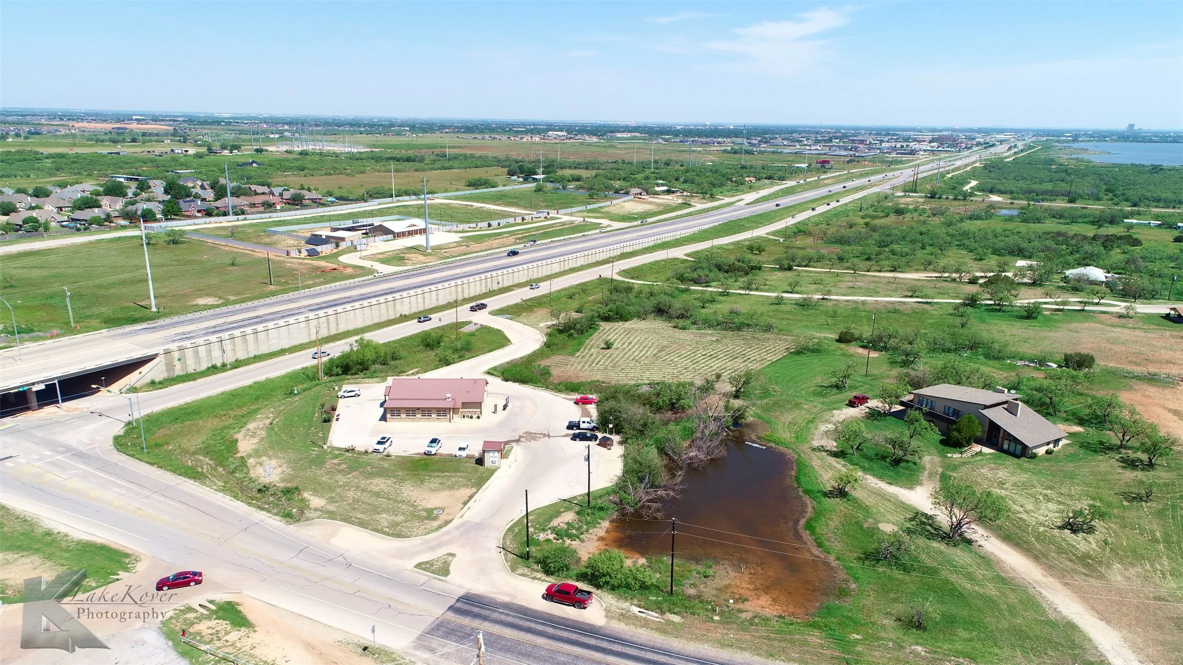 Aerial view of sparsely populated area featuring a nearby body of water and extensive farmland