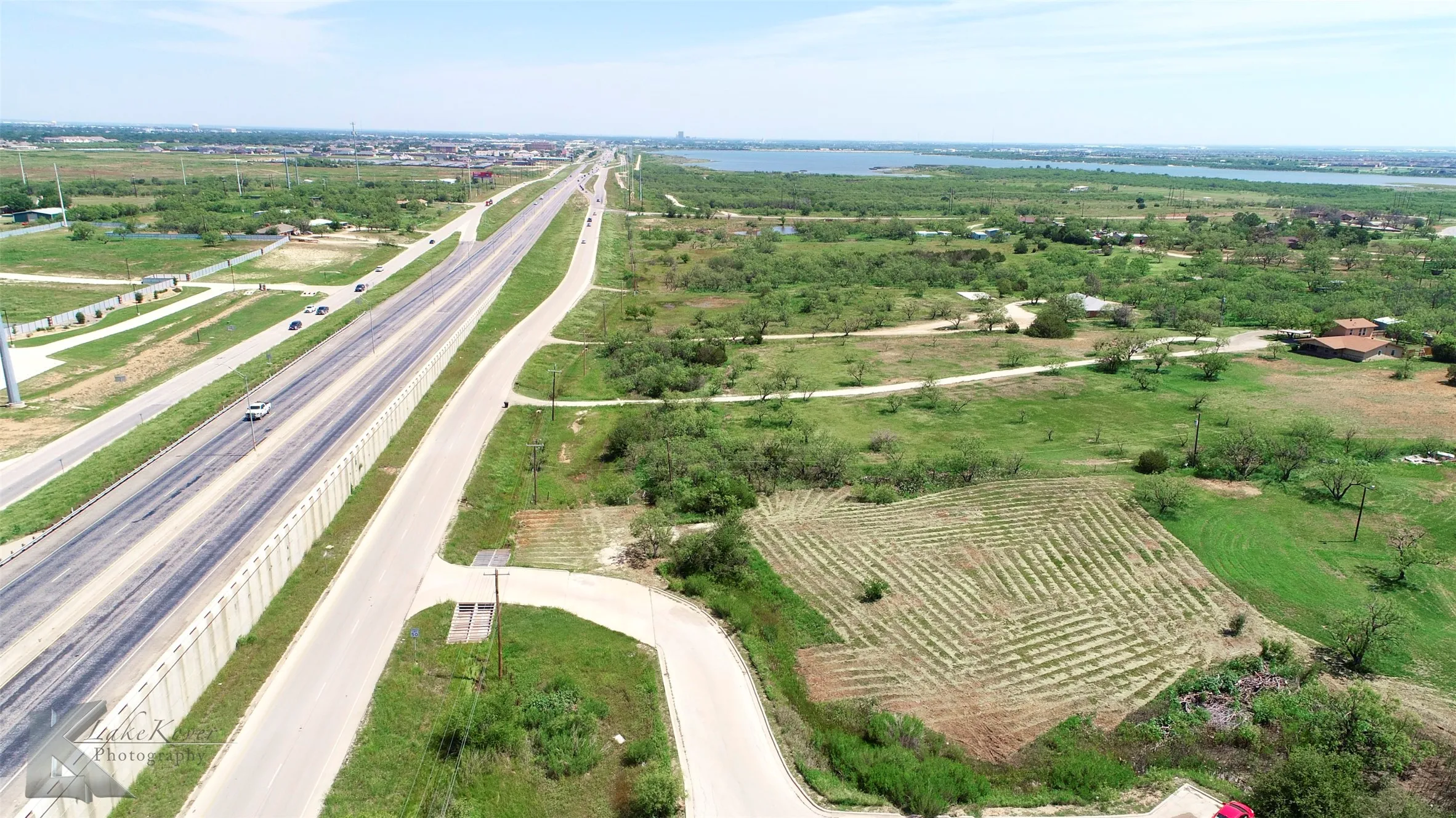 View of rural area with a large body of water and a highway
