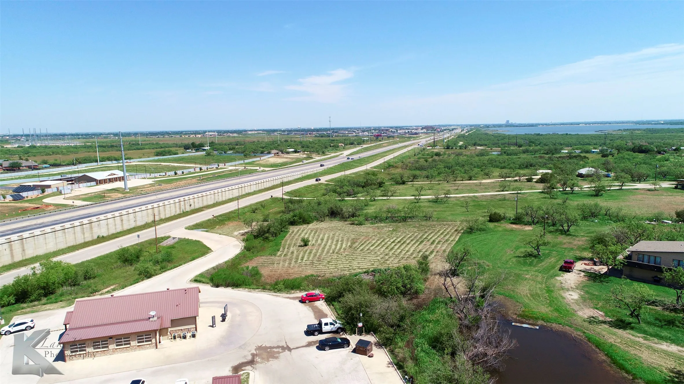 Overview of rural landscape featuring rows of crops and a nearby body of water
