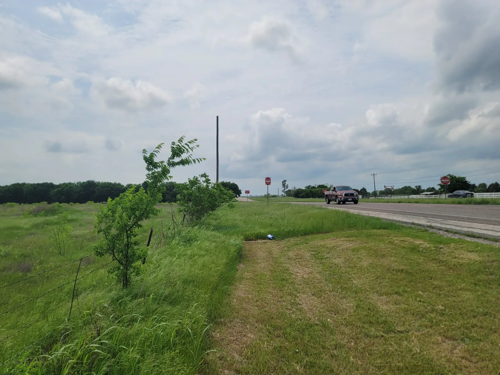 View of asphalt street with traffic signs and a rural view