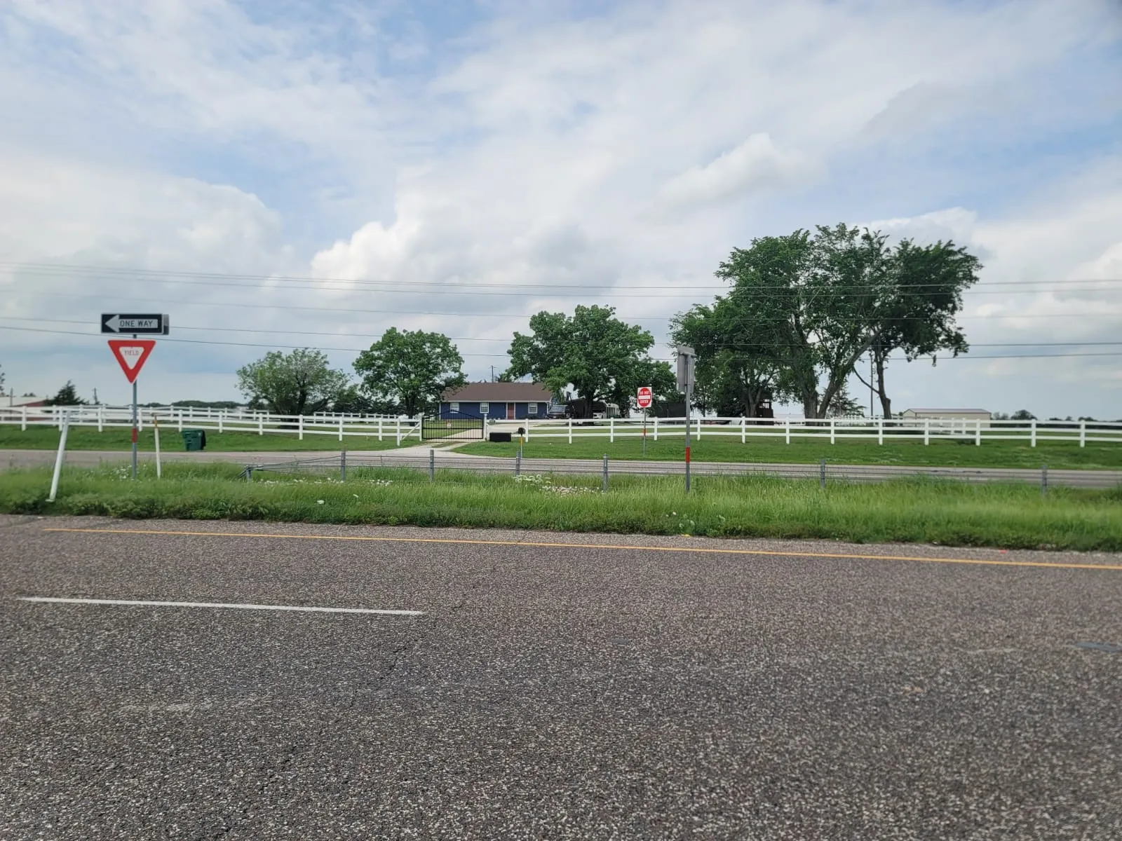 View of asphalt street featuring traffic signs