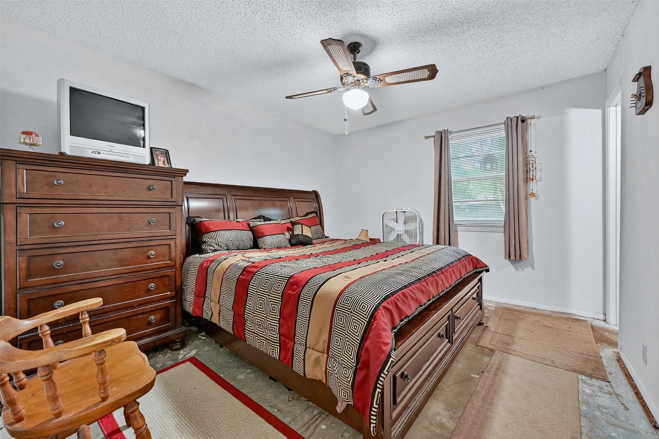 Bedroom with a textured ceiling and a ceiling fan