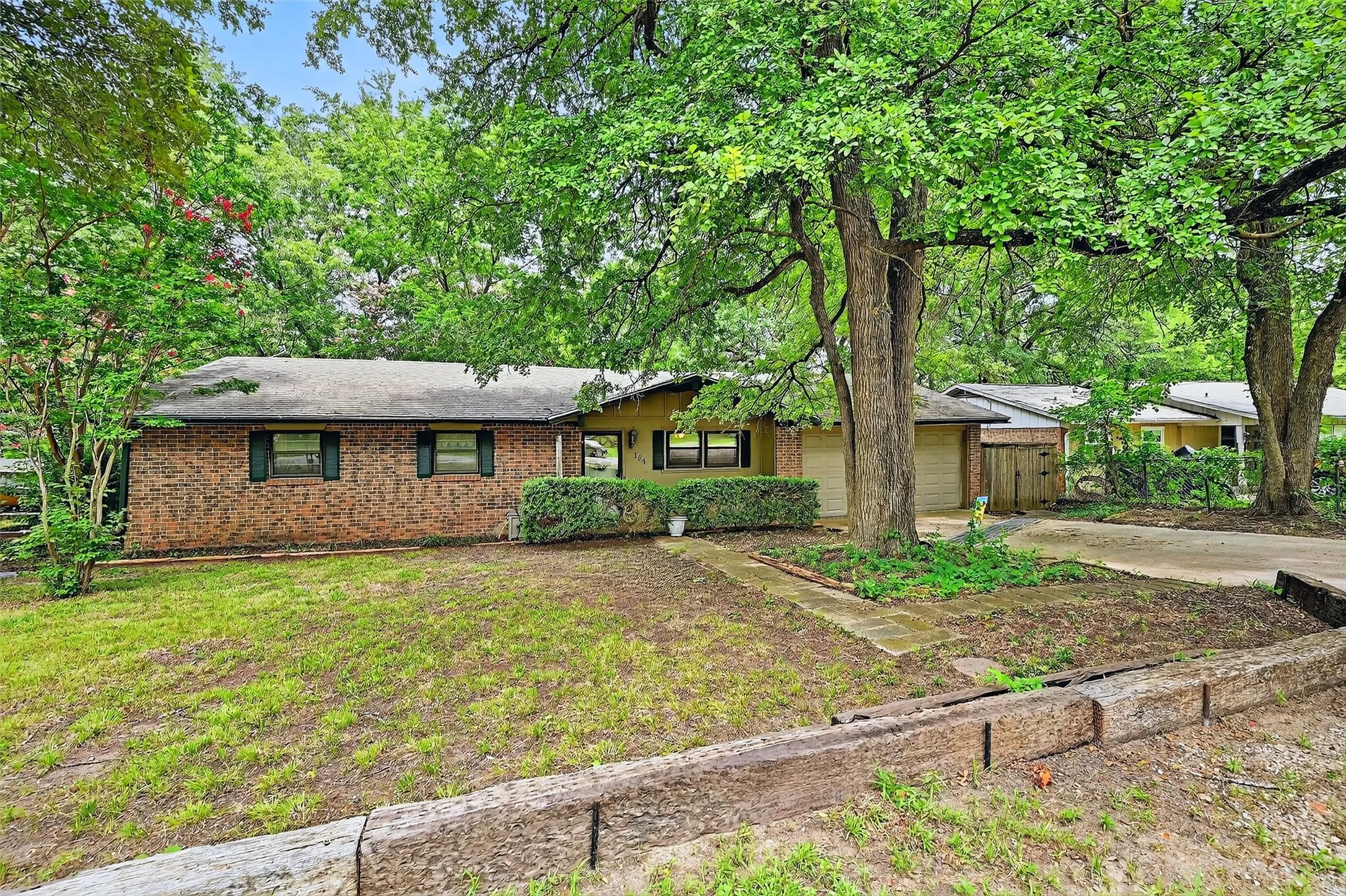 View of front of house featuring concrete driveway, a garage, and brick siding