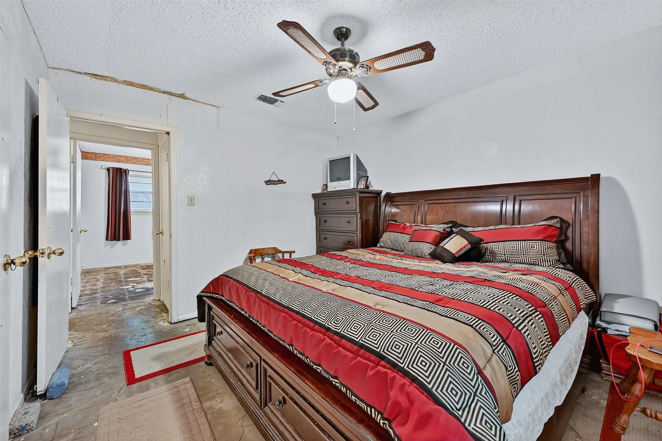 Bedroom with a textured ceiling and ceiling fan