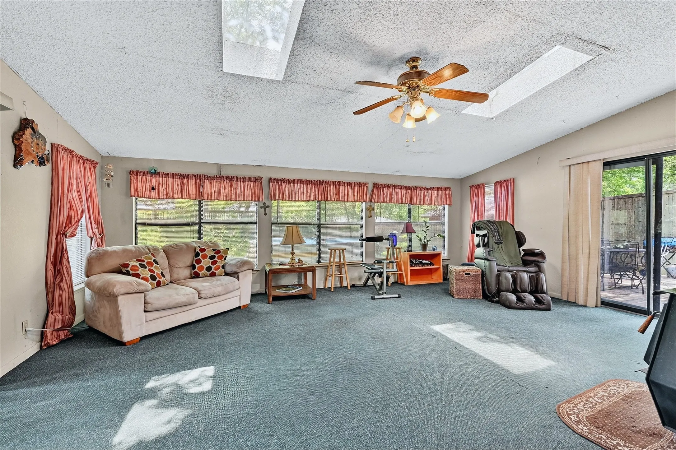 Sunroom / solarium with a skylight, a textured ceiling, and carpet