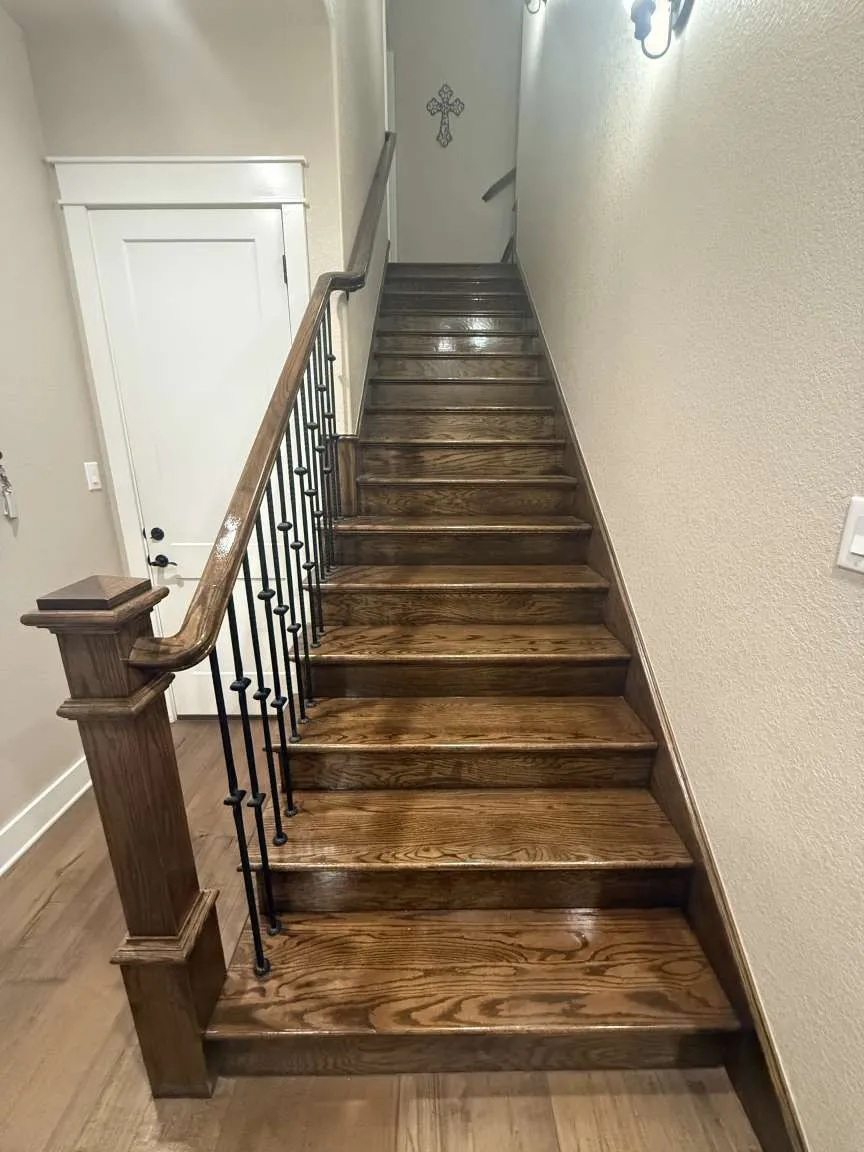 Staircase with wood finished floors and baseboards