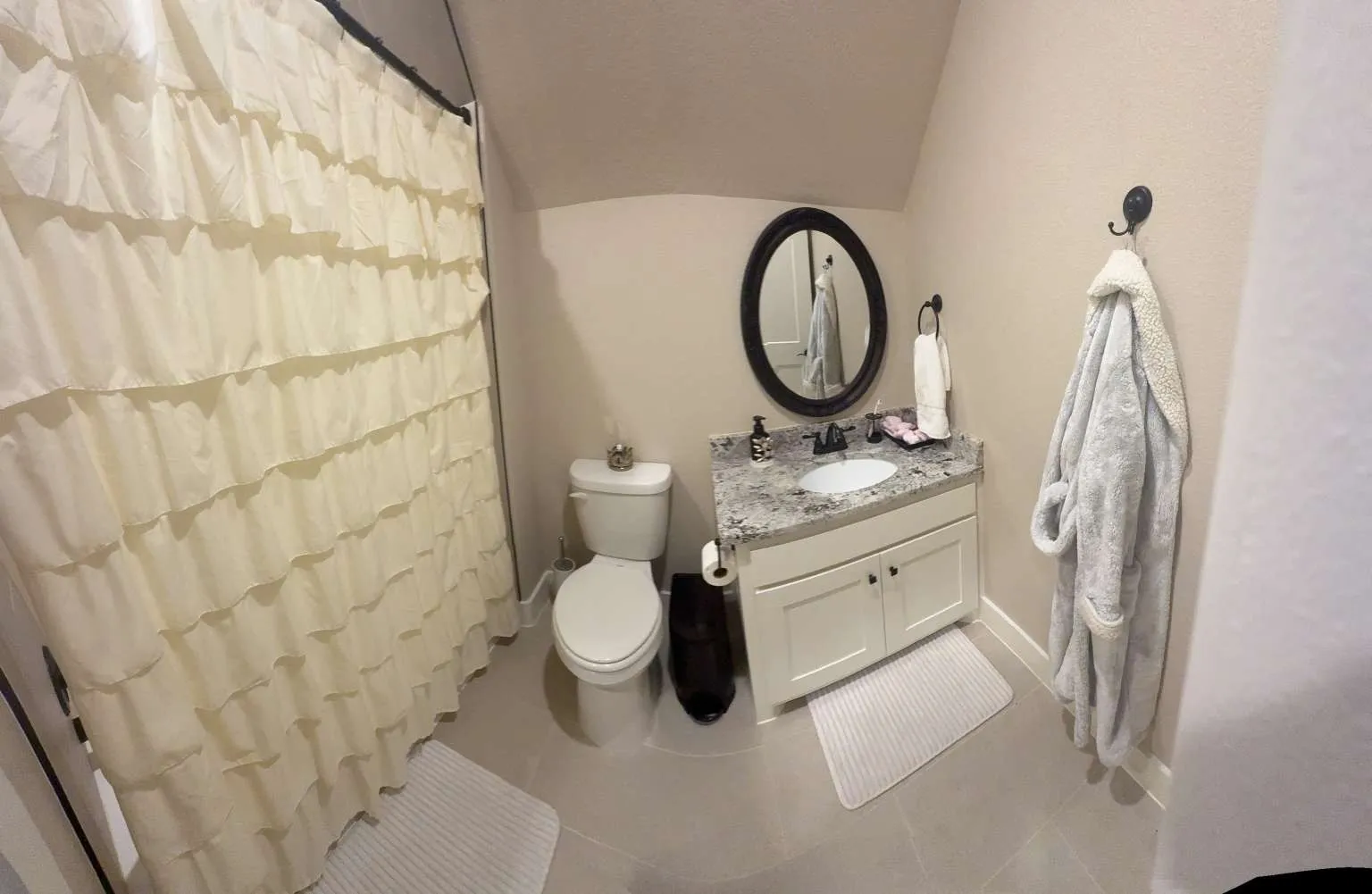 Full bathroom featuring vanity, vaulted ceiling, tile patterned flooring, and a shower with shower curtain
