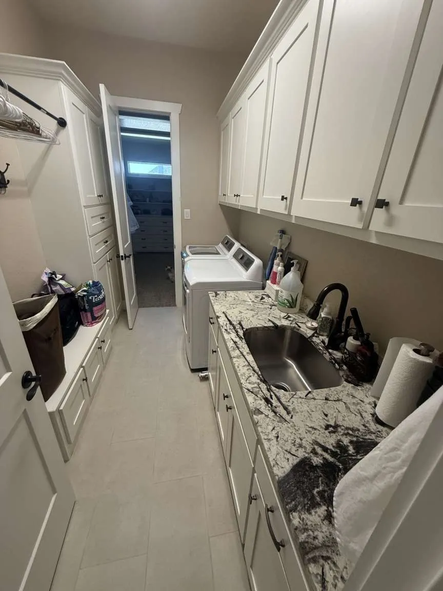 Laundry room featuring cabinet space, washing machine and dryer, and light tile patterned floors
