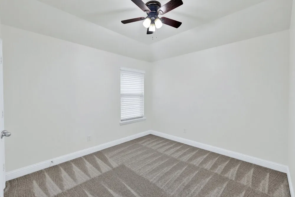 Carpeted bedroom featuring baseboards and a ceiling fan