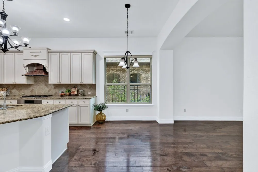 Kitchen with a chandelier, light stone counters, tasteful backsplash, dark wood-style floors, and pendant lighting