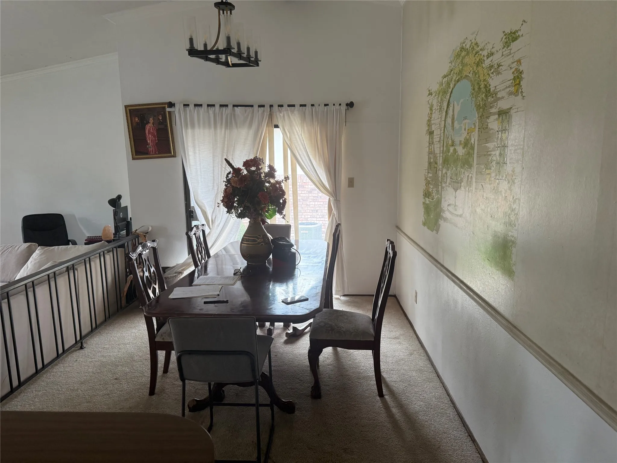 Dining room with light colored carpet and ornamental molding