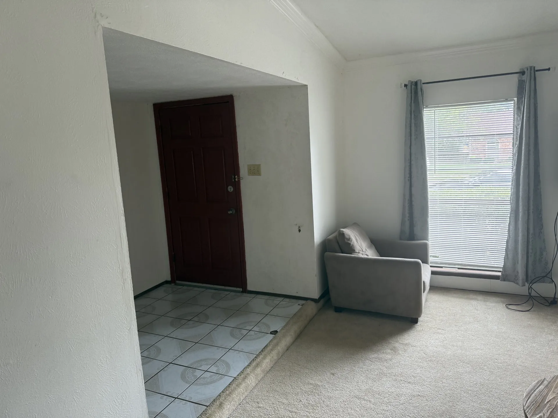 Entryway featuring ornamental molding and light colored carpet