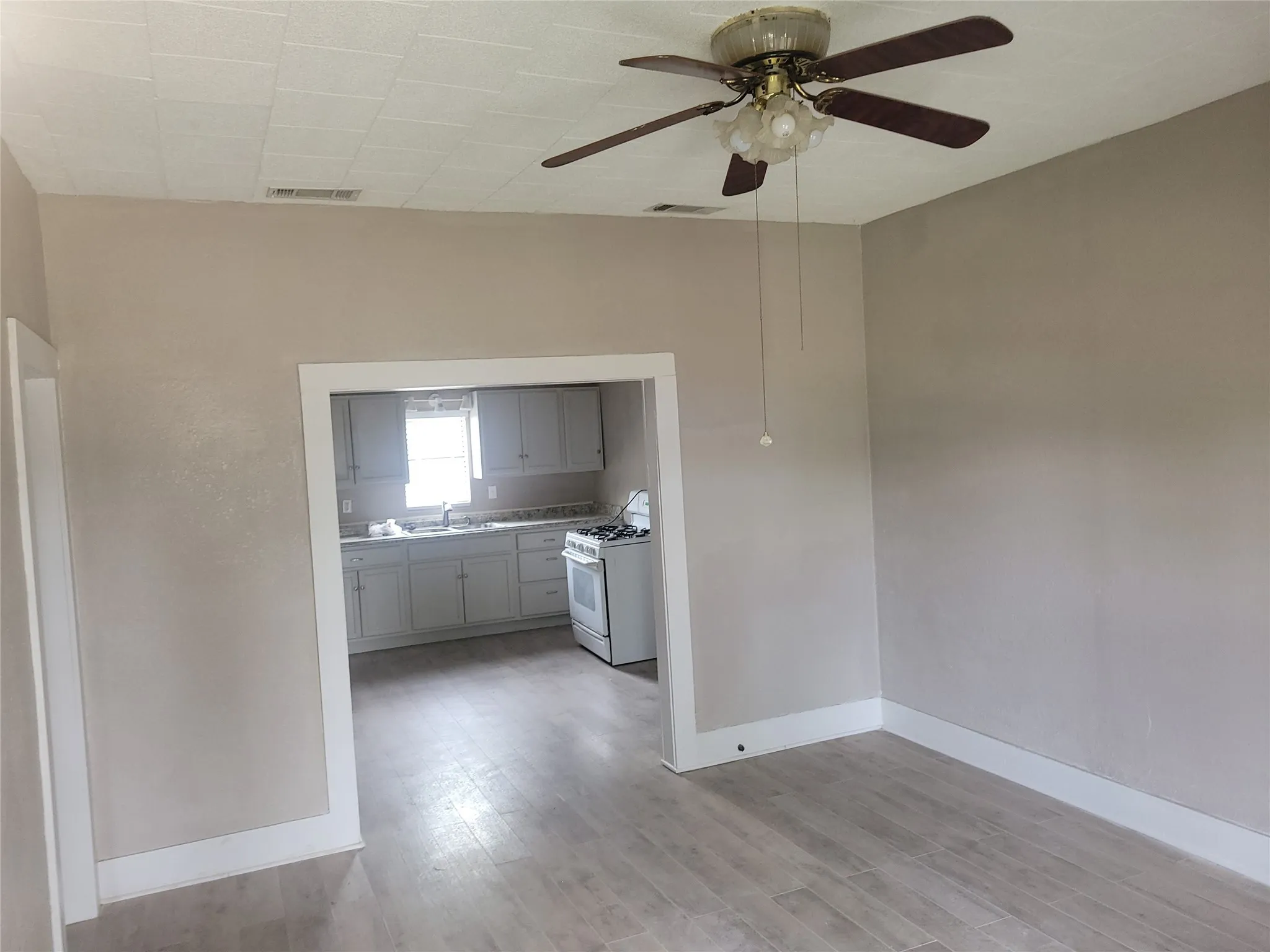 Empty room featuring a ceiling fan and light wood-type flooring