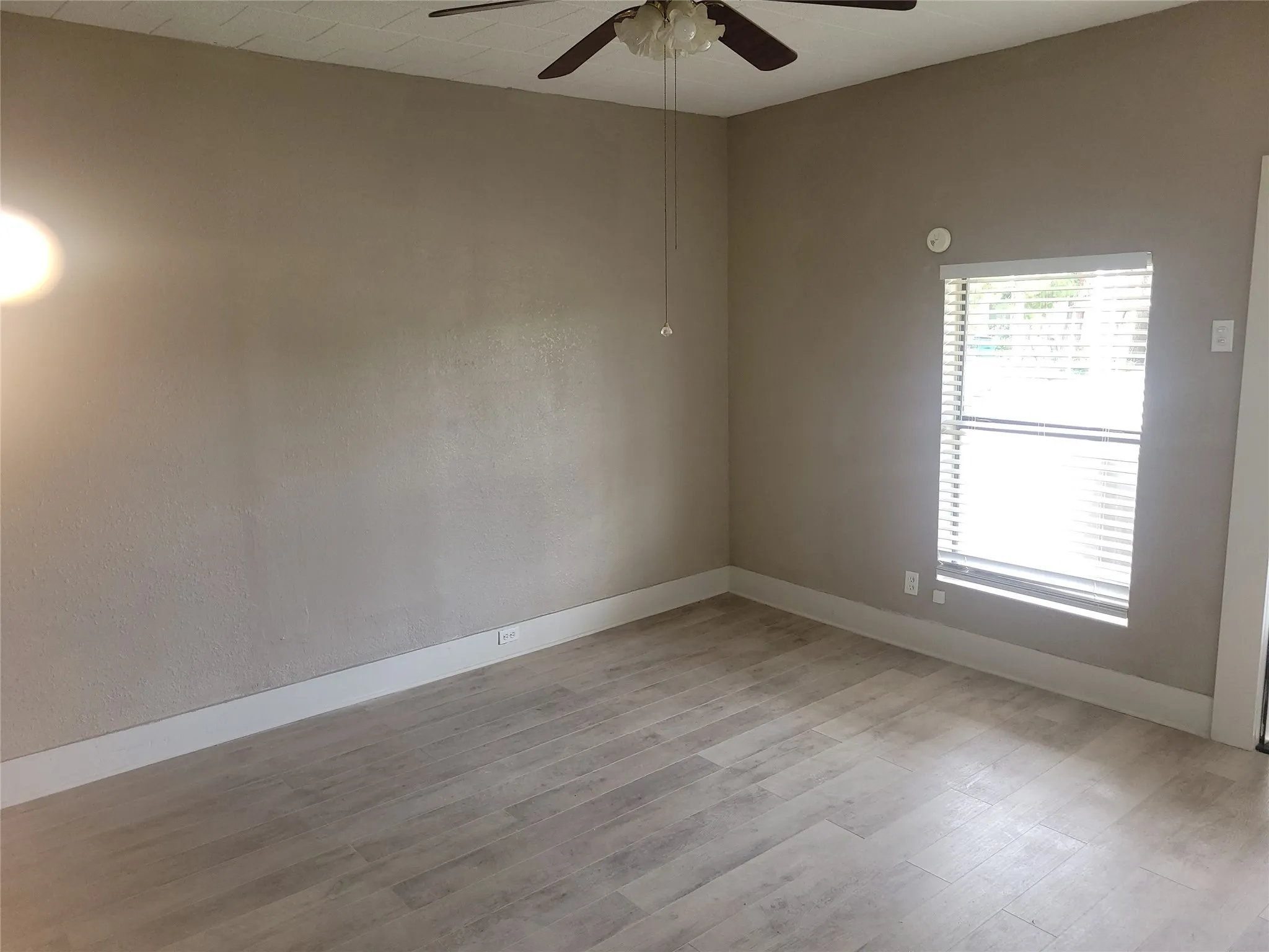 Spare room with ceiling fan and light wood finished floors