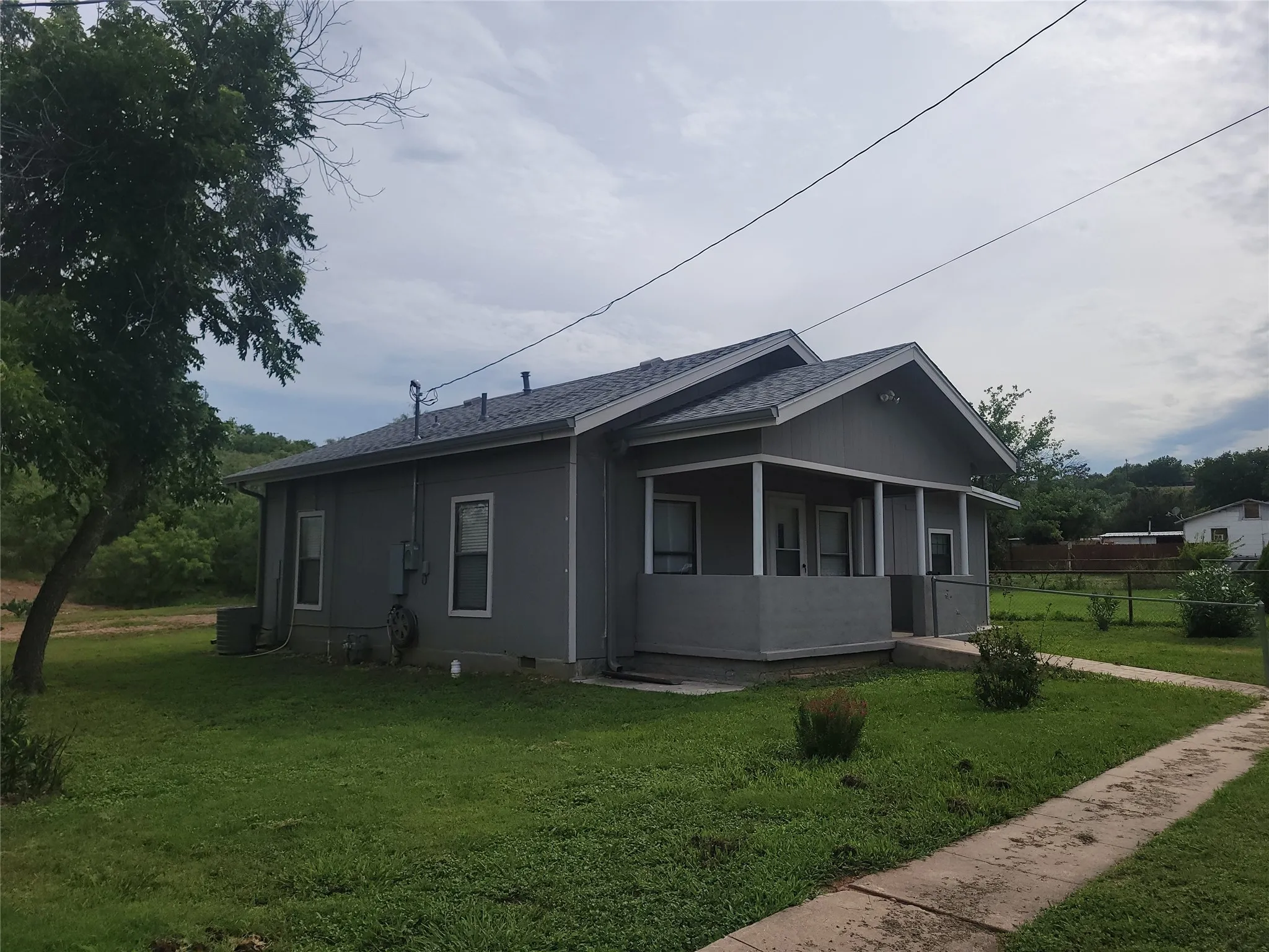 View of side of home featuring roof with shingles and a sunroom