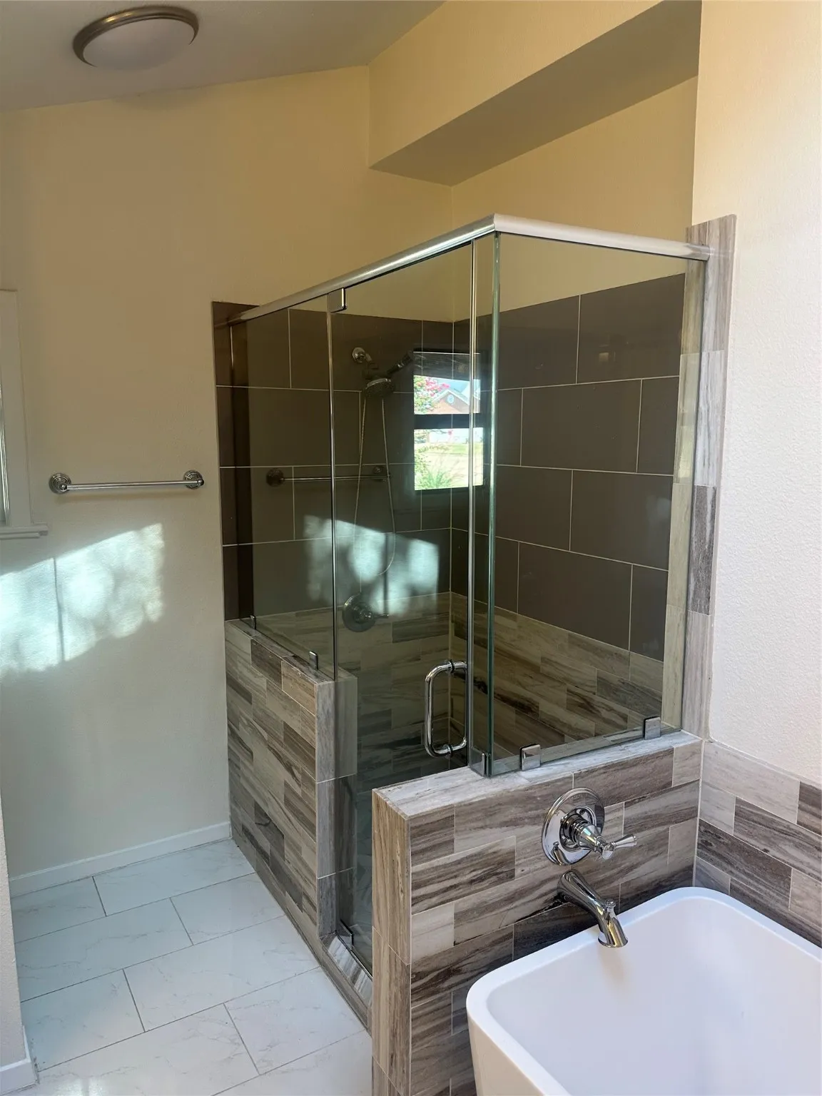 Full bathroom featuring a freestanding bath, a shower stall, and marble look tiles