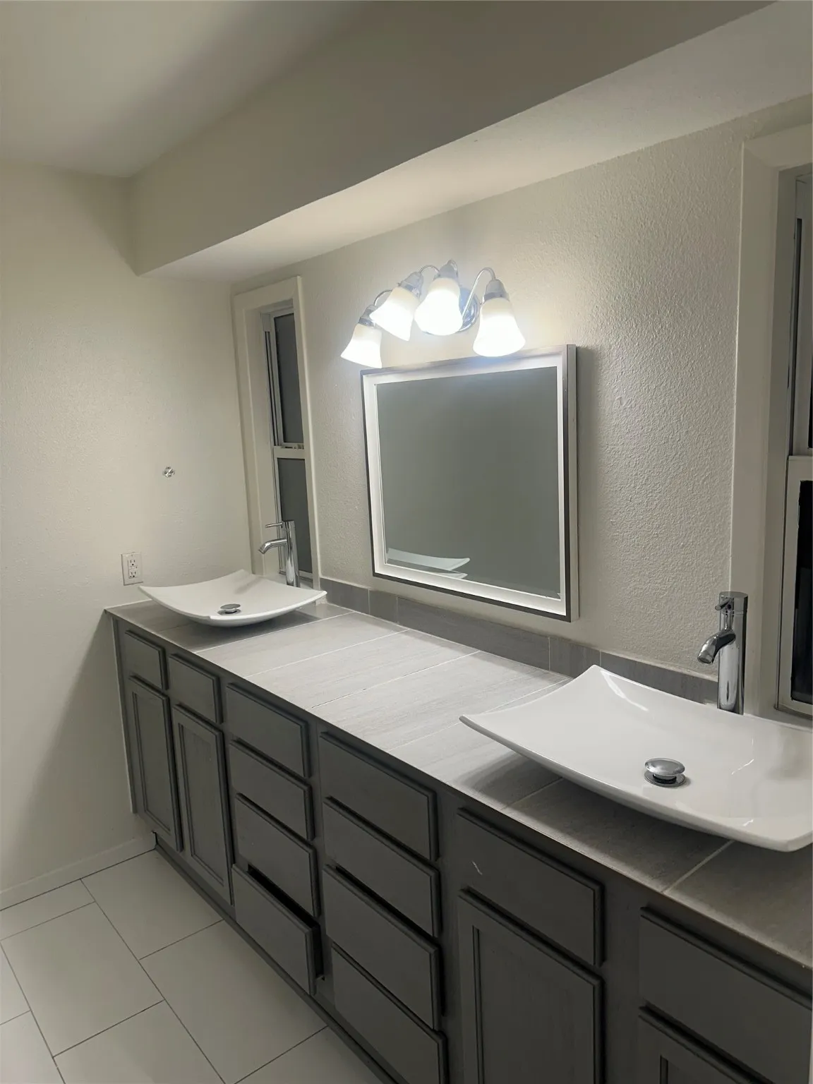 Full bath featuring double vanity and tile patterned floors