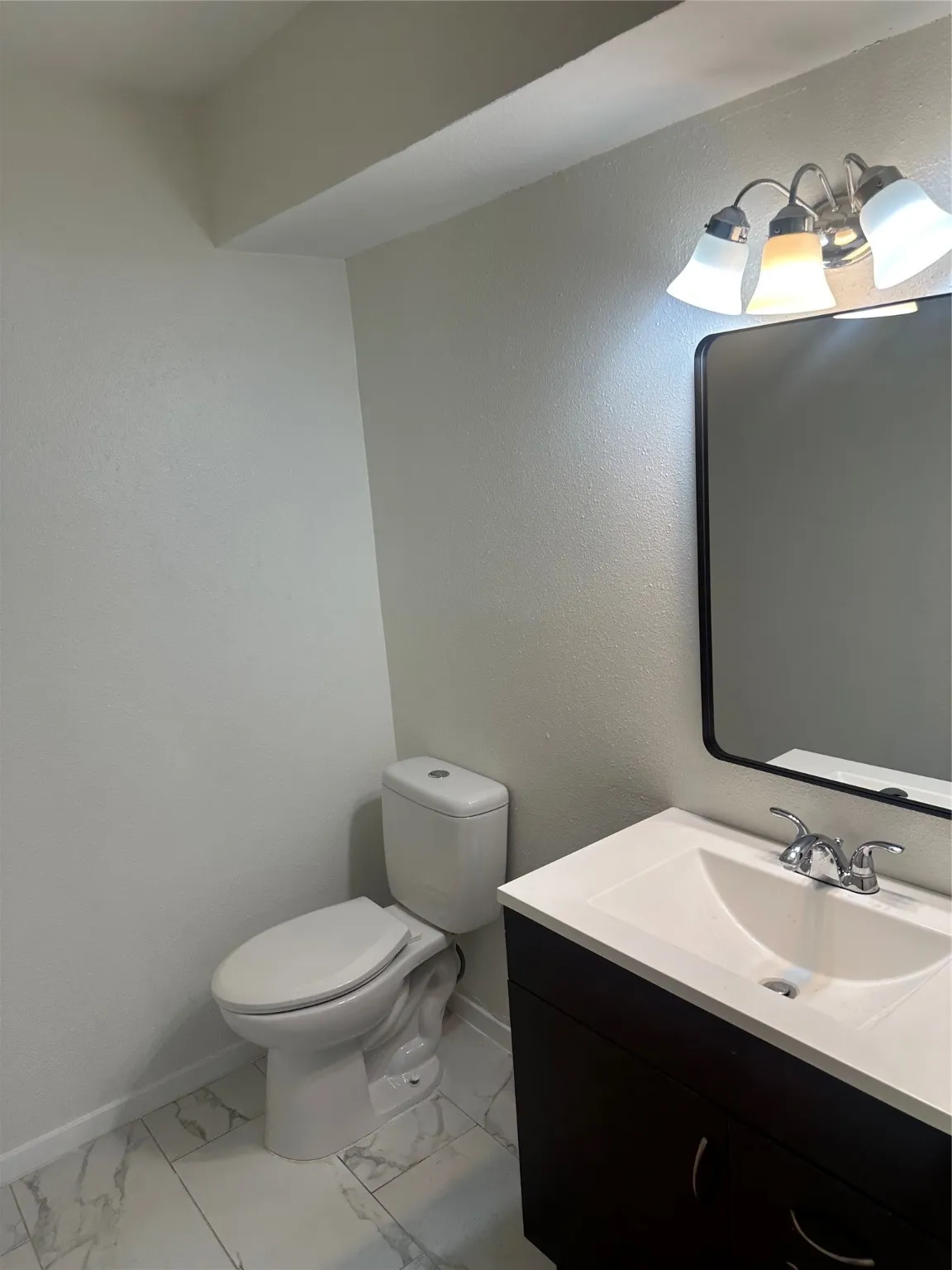 Bathroom with vanity and marble look tile flooring