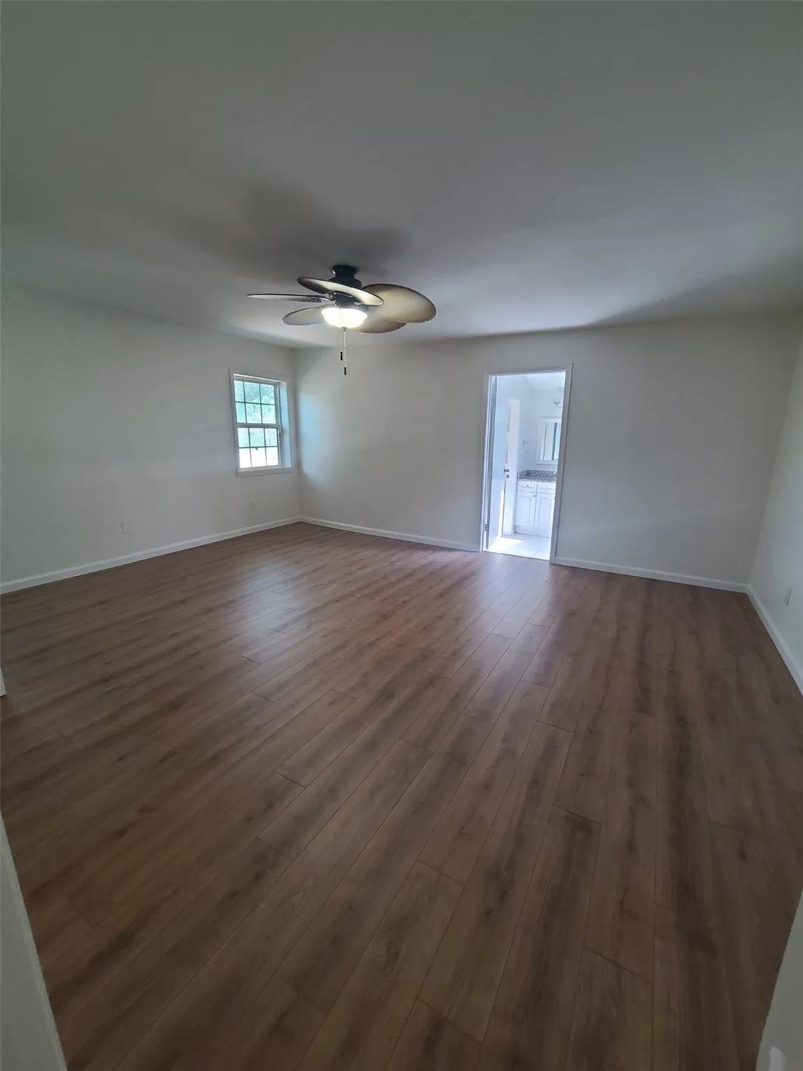 Bedroom with dark wood finished floors and a ceiling fan