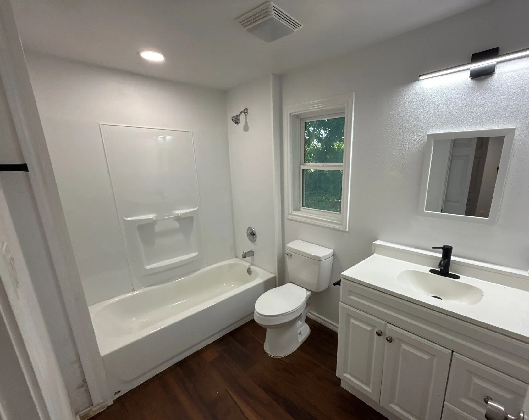 Bathroom featuring wood finished floors, vanity, shower / washtub combination, and recessed lighting
