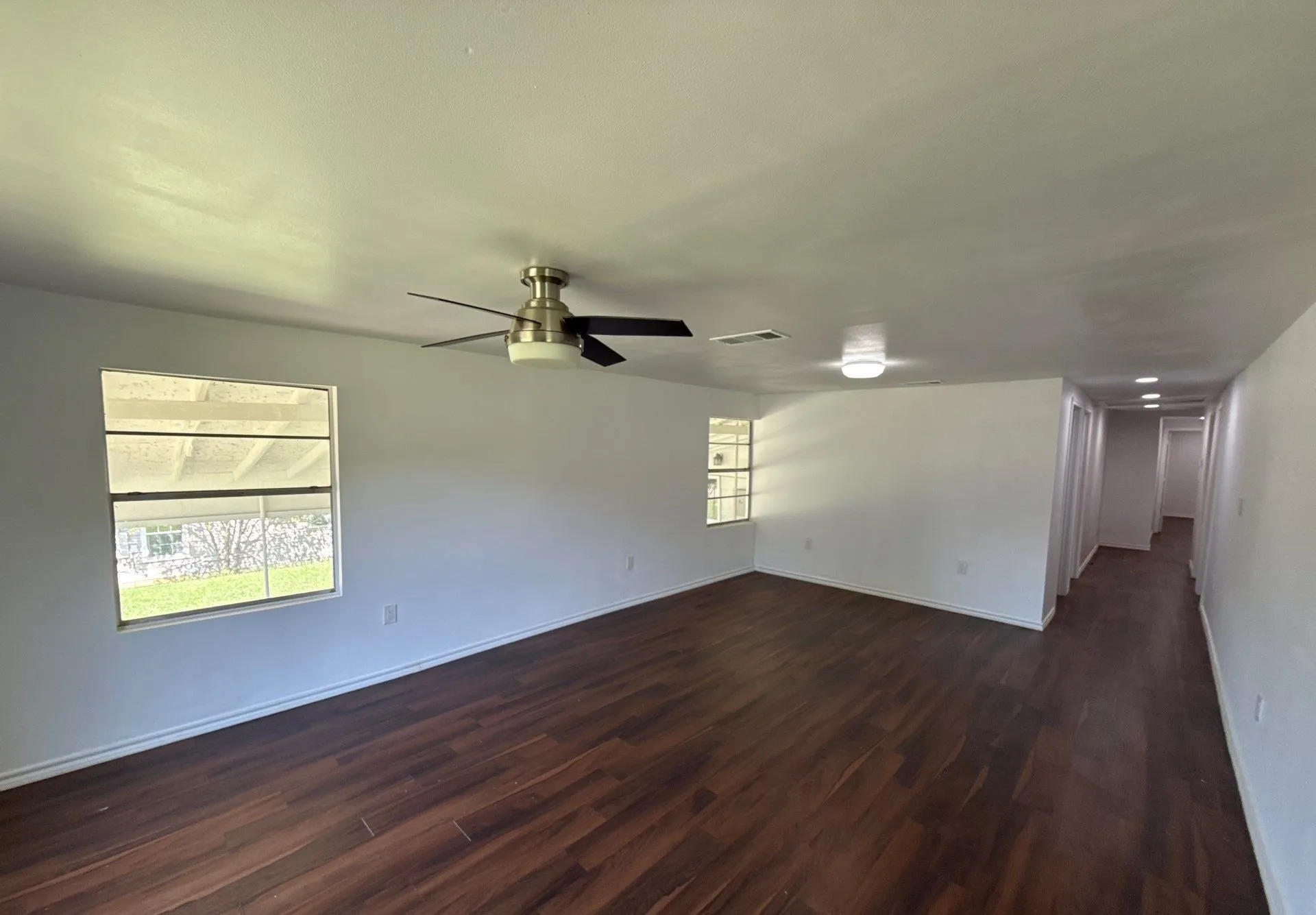Unfurnished room with dark wood-style floors and a ceiling fan