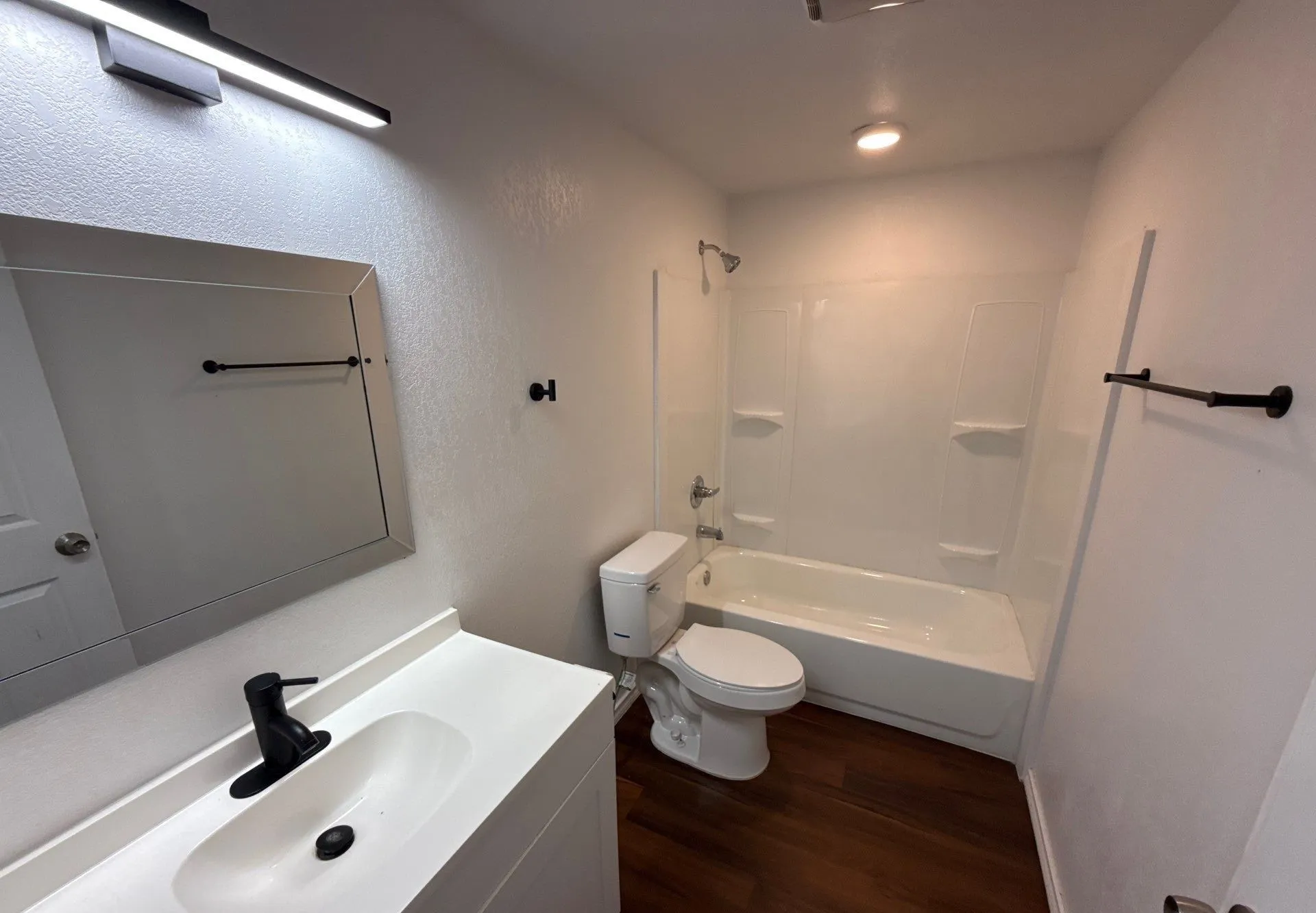 Bathroom with wood finished floors, vanity, and shower / bathtub combination