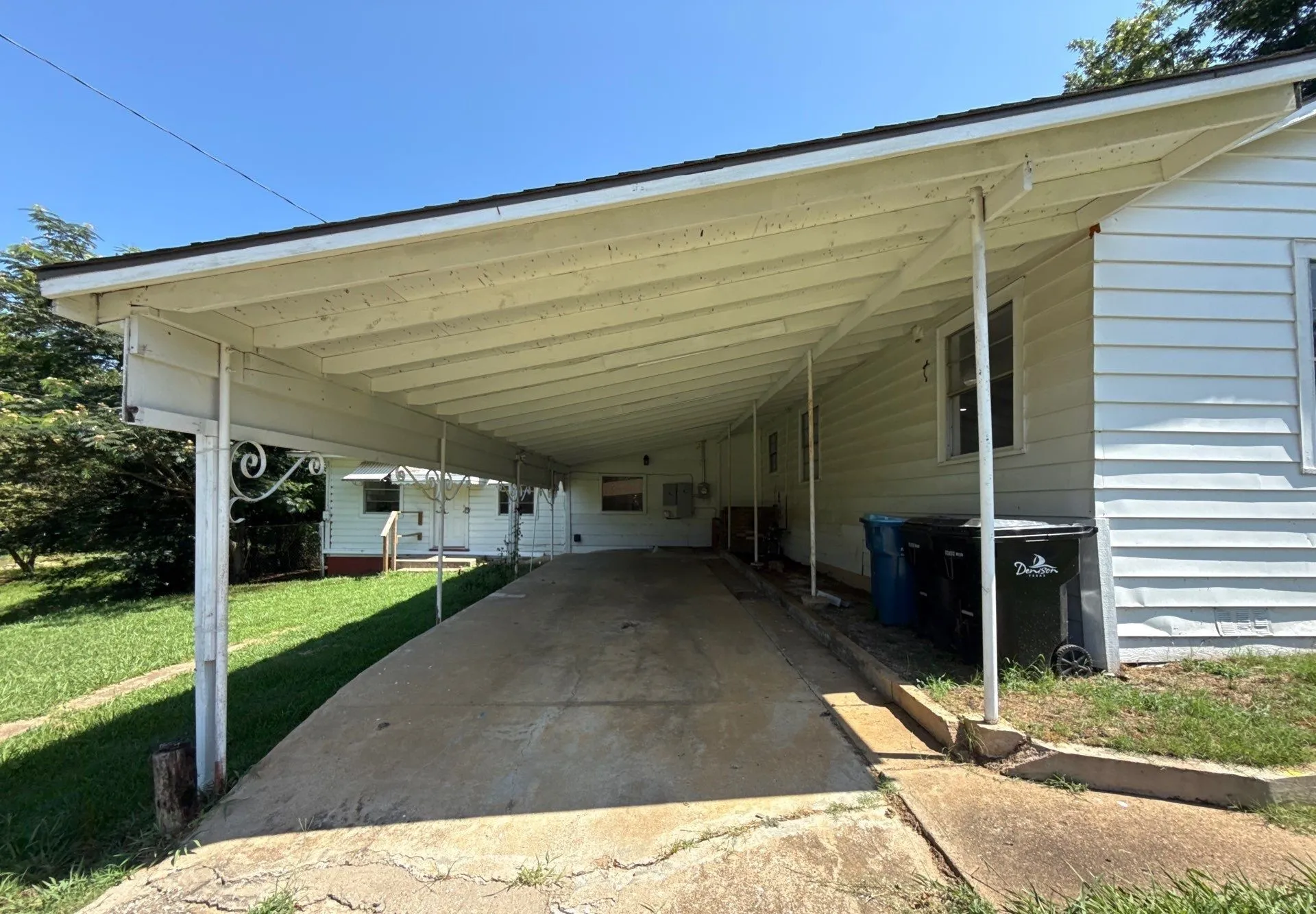 View of parking / parking lot with a carport and driveway