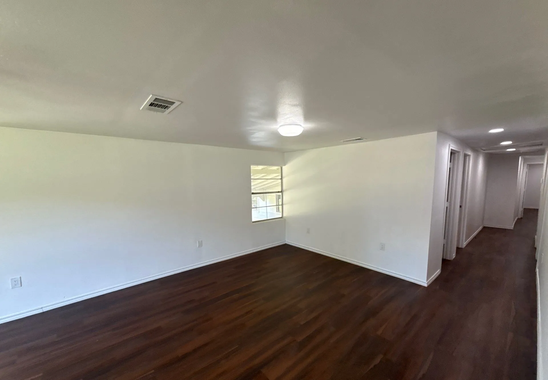 Unfurnished room with dark wood-style floors and baseboards