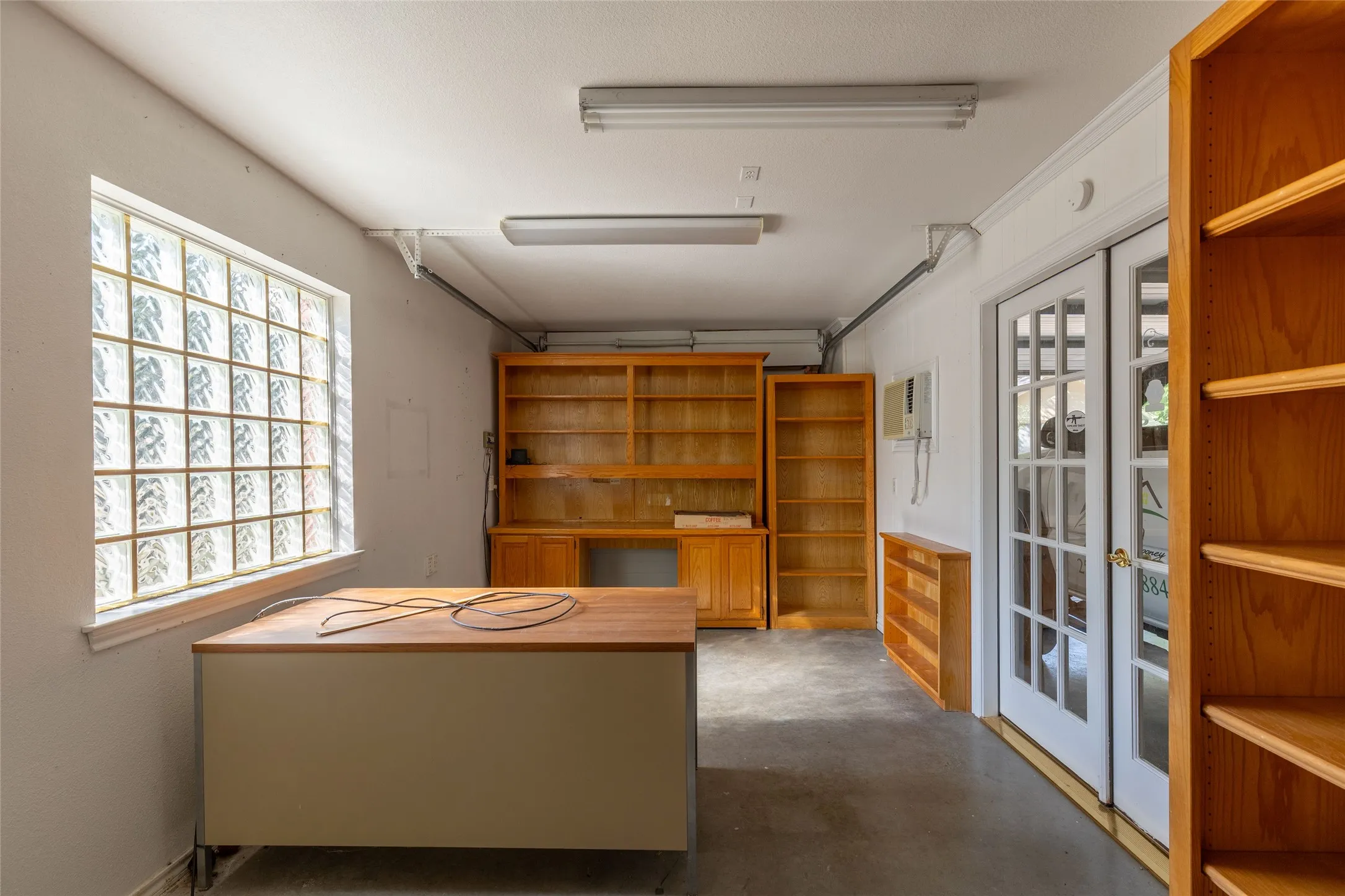 Unfurnished office featuring concrete flooring and french doors